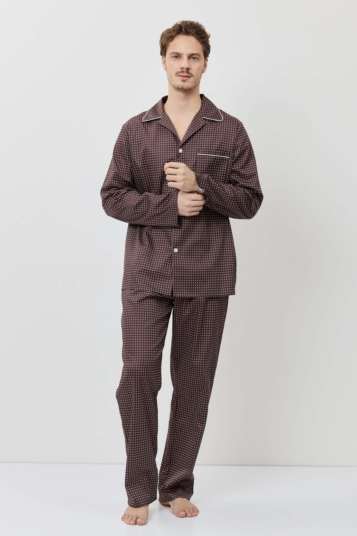 Man wearing a brown checkered pajama set against a white background