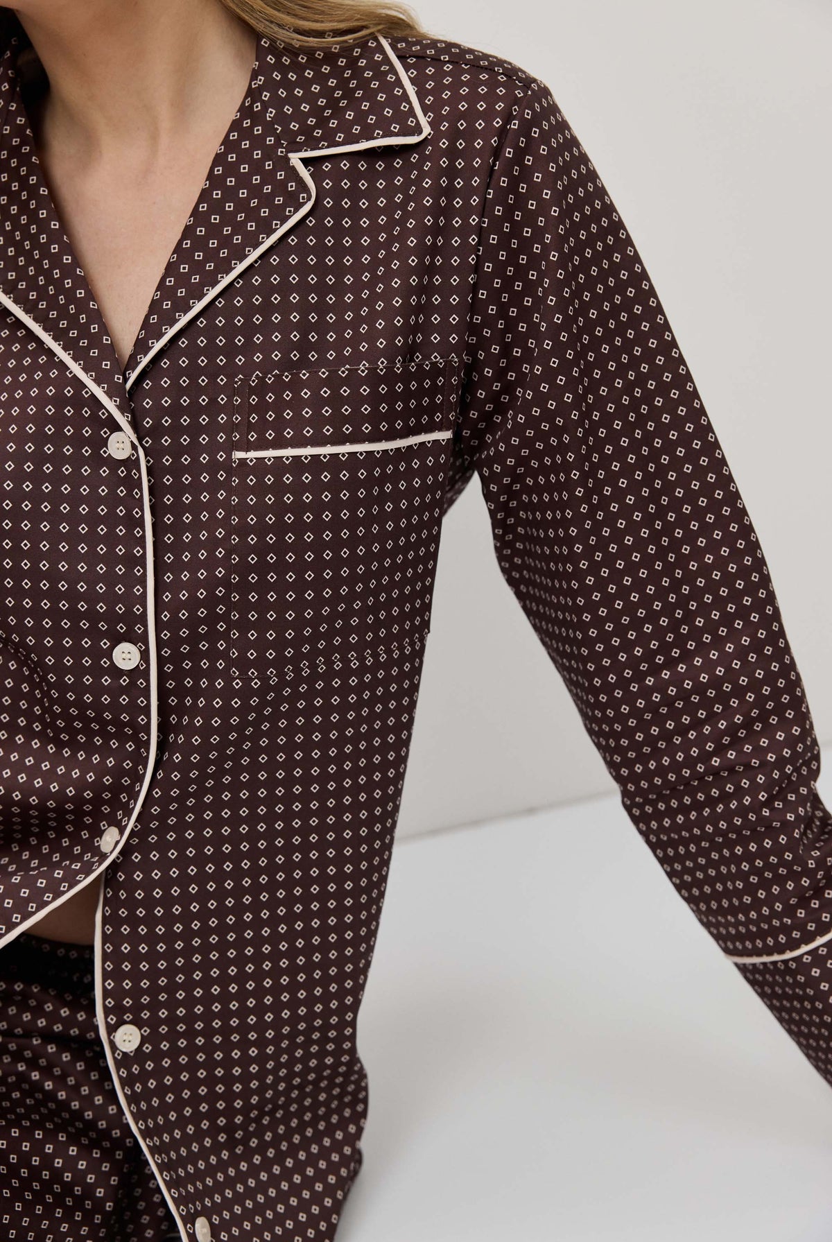 Brown patterned pajama top with white trim on a neutral background