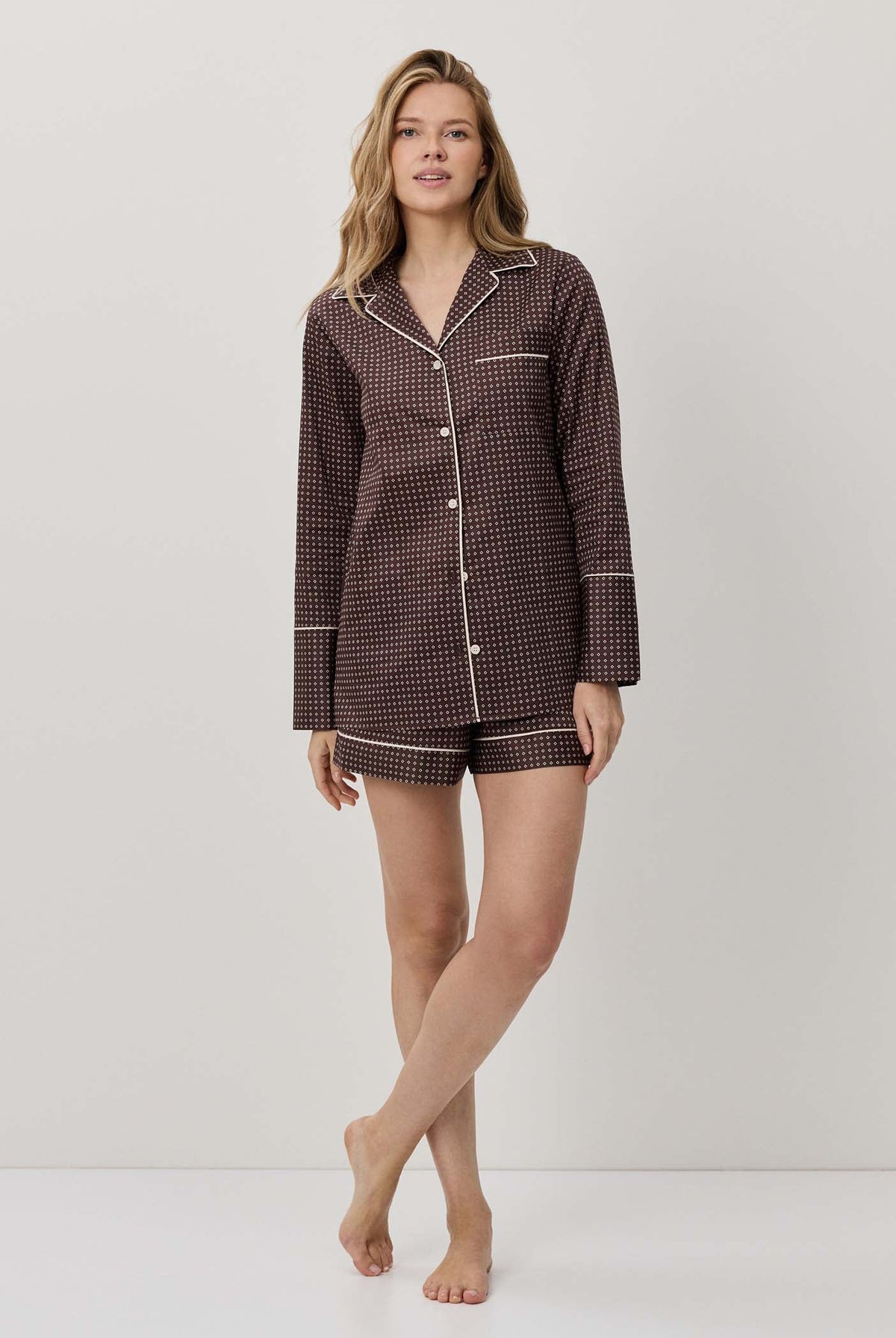 Woman wearing a brown checkered pajama set on a white background