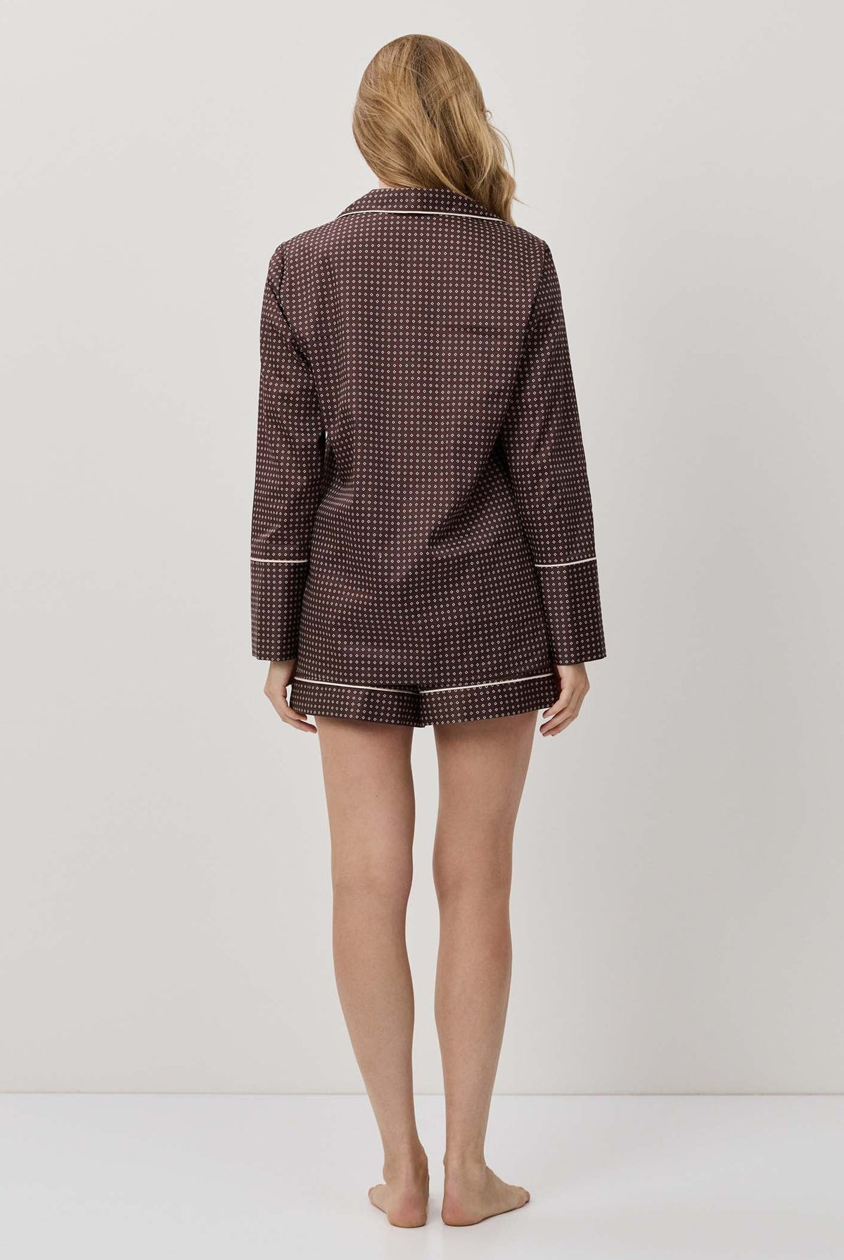 Person wearing a brown checkered outfit on a white background