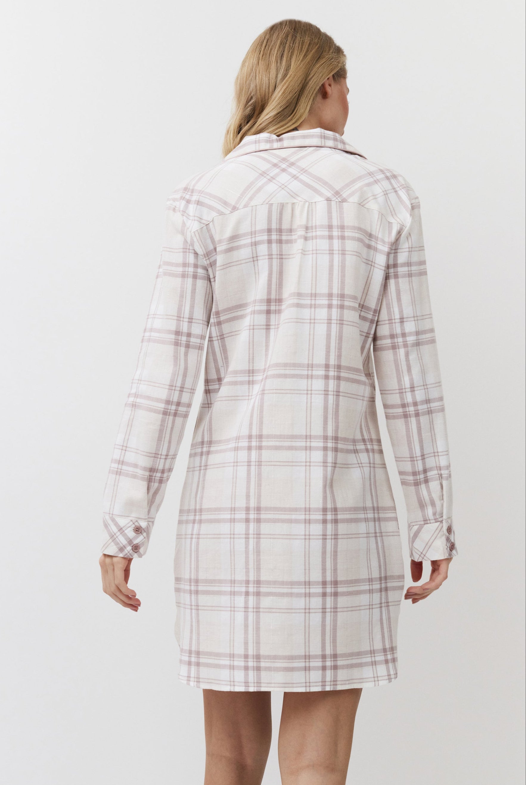 Woman wearing a plaid dress against a white background