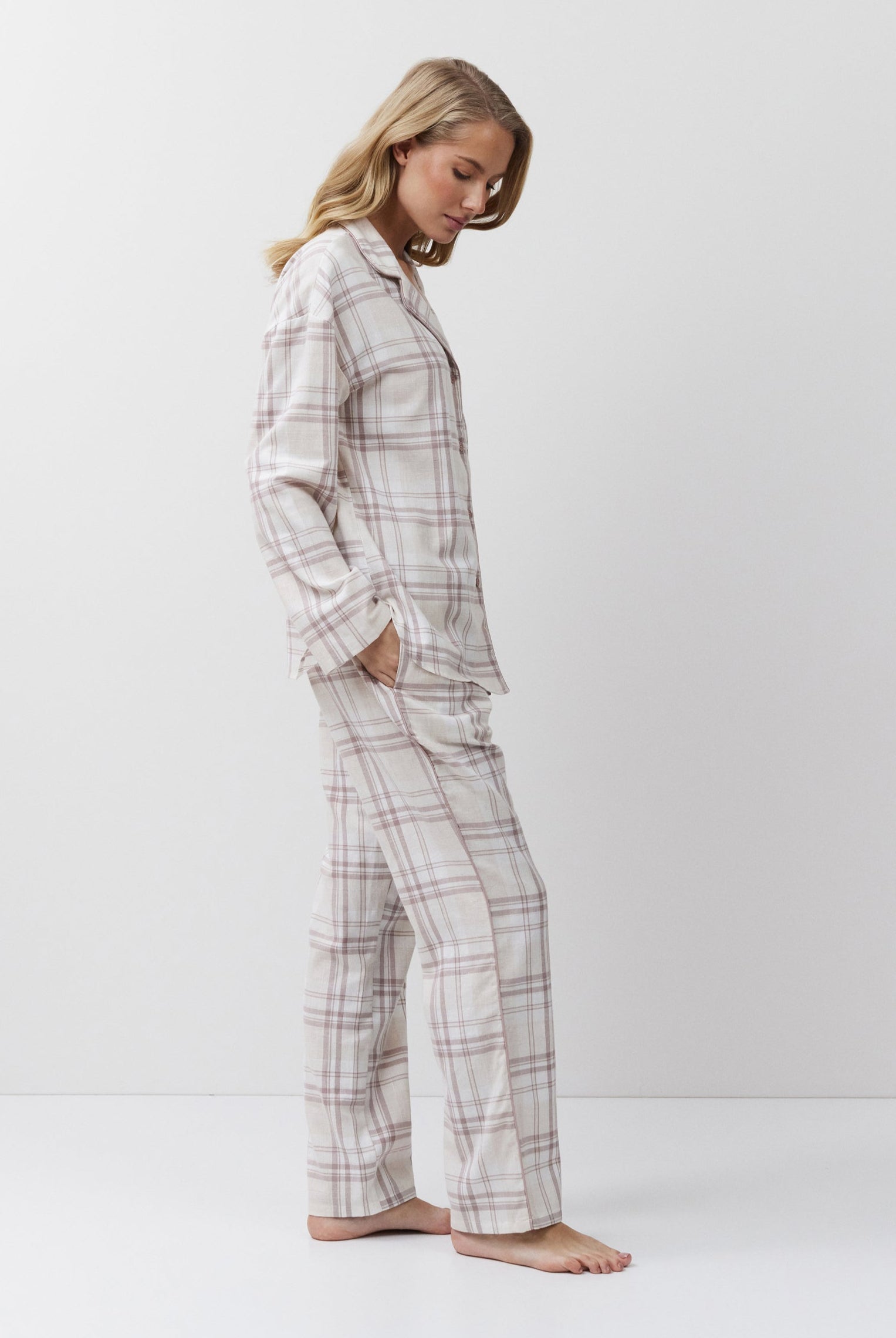 Woman wearing a plaid pajama set on a white background