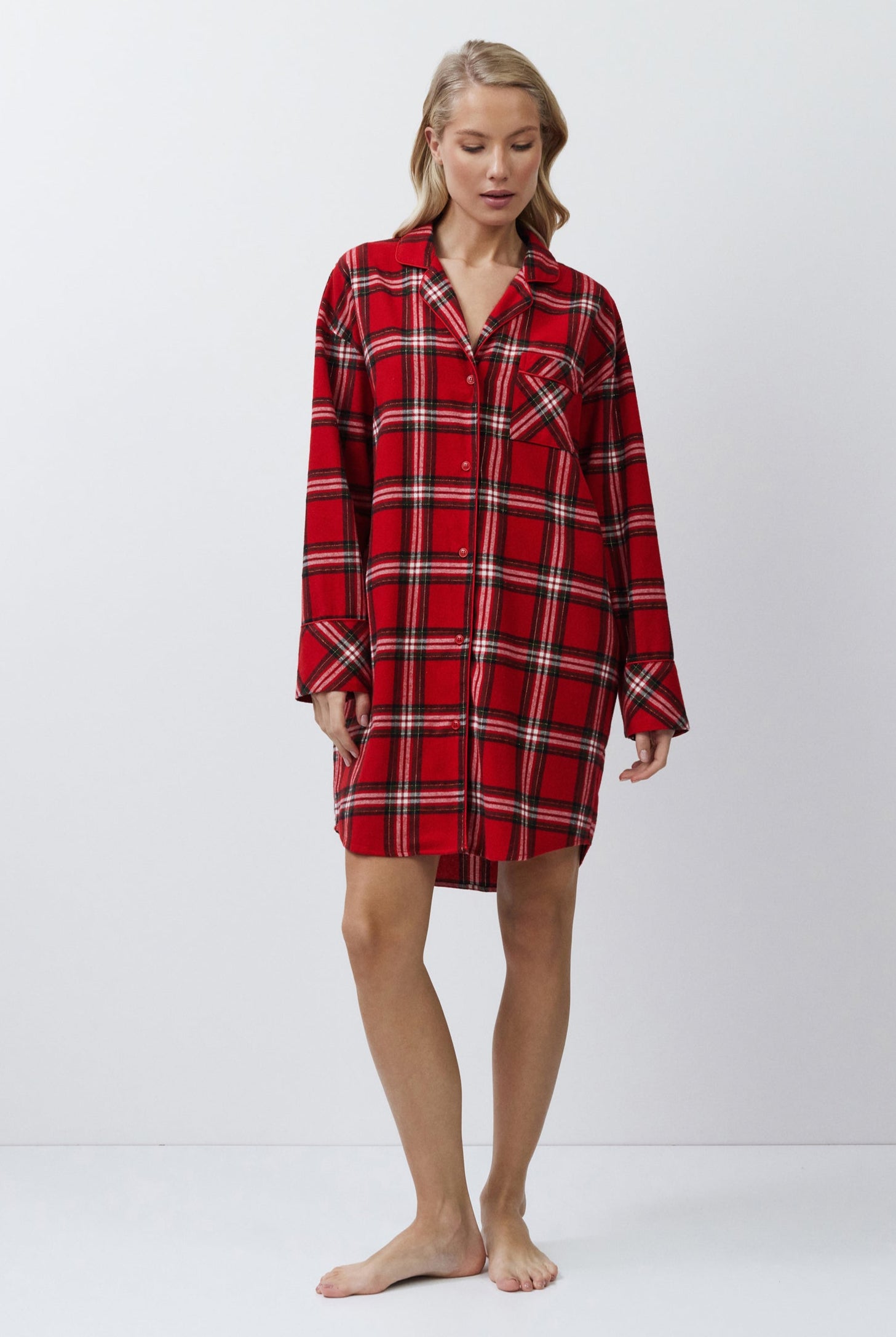 Person wearing a red plaid nightshirt on a white background