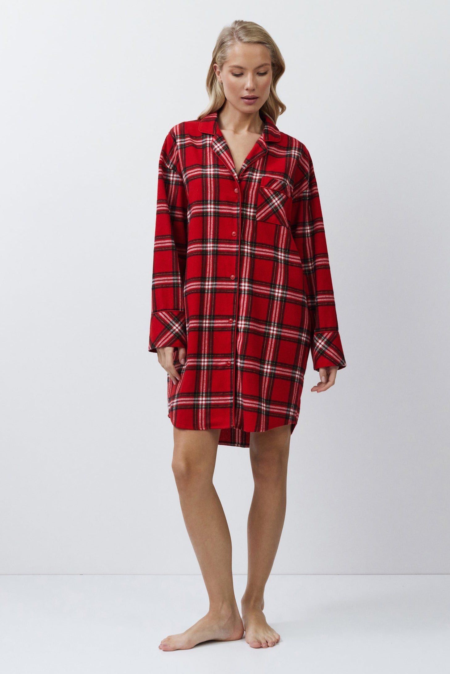 Person wearing a red plaid nightshirt on a white background