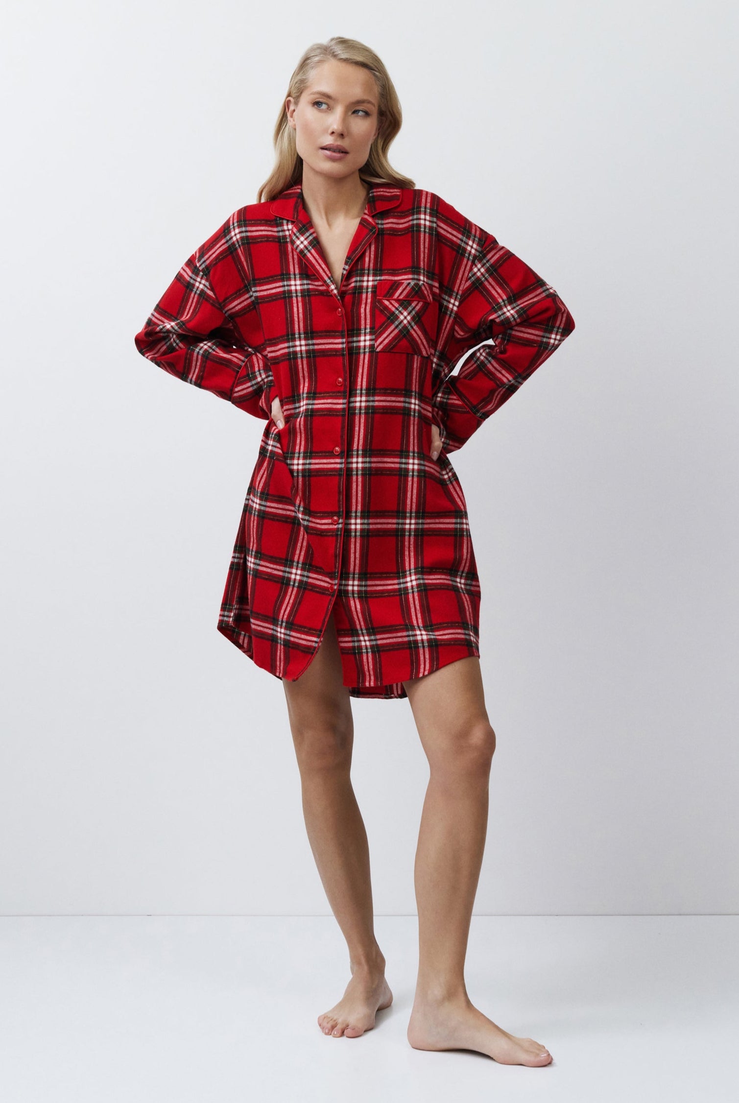 Person wearing a red plaid shirt dress on a white background