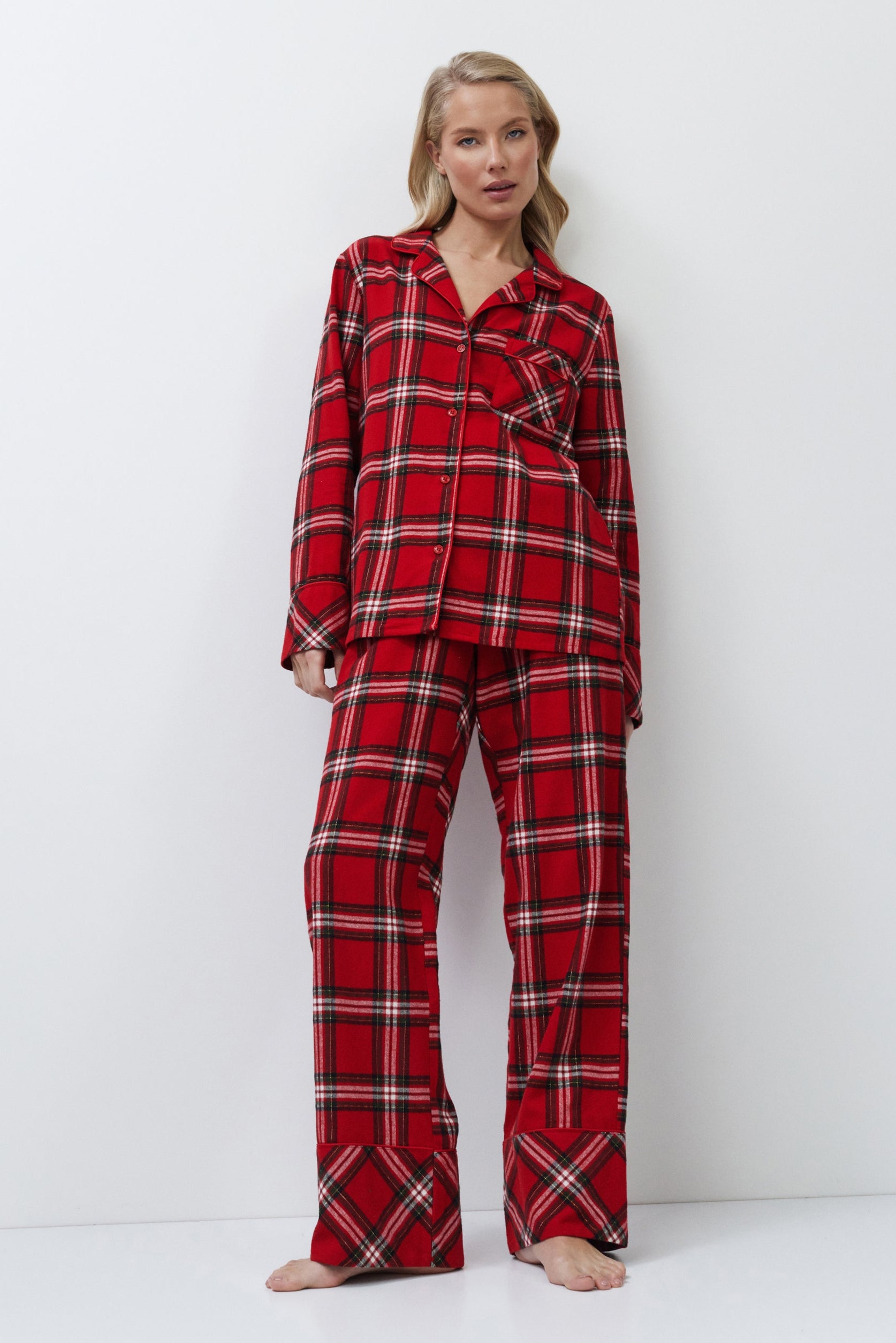 Woman wearing red plaid pajamas on a white background
