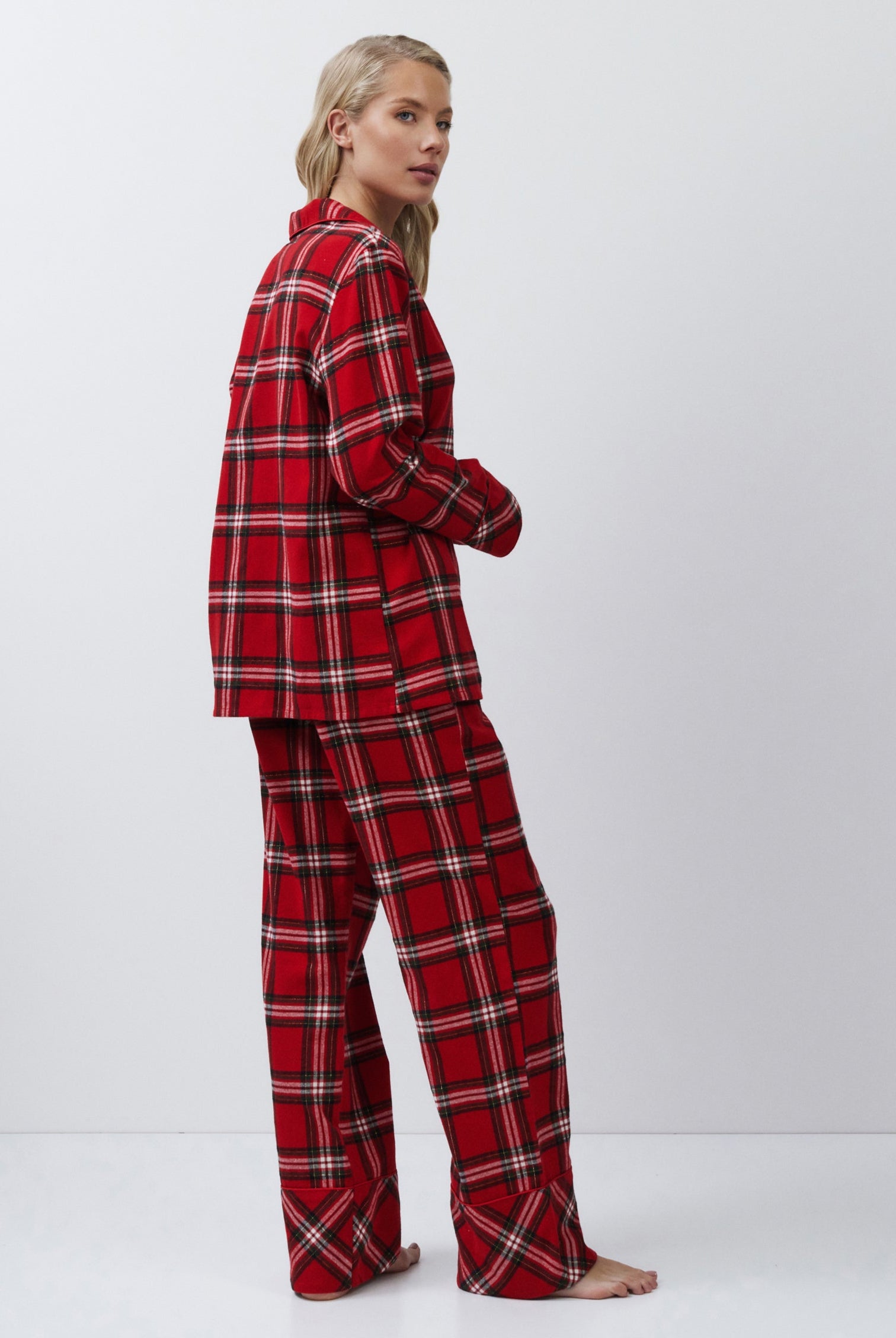 Person wearing red plaid pajamas on a white background