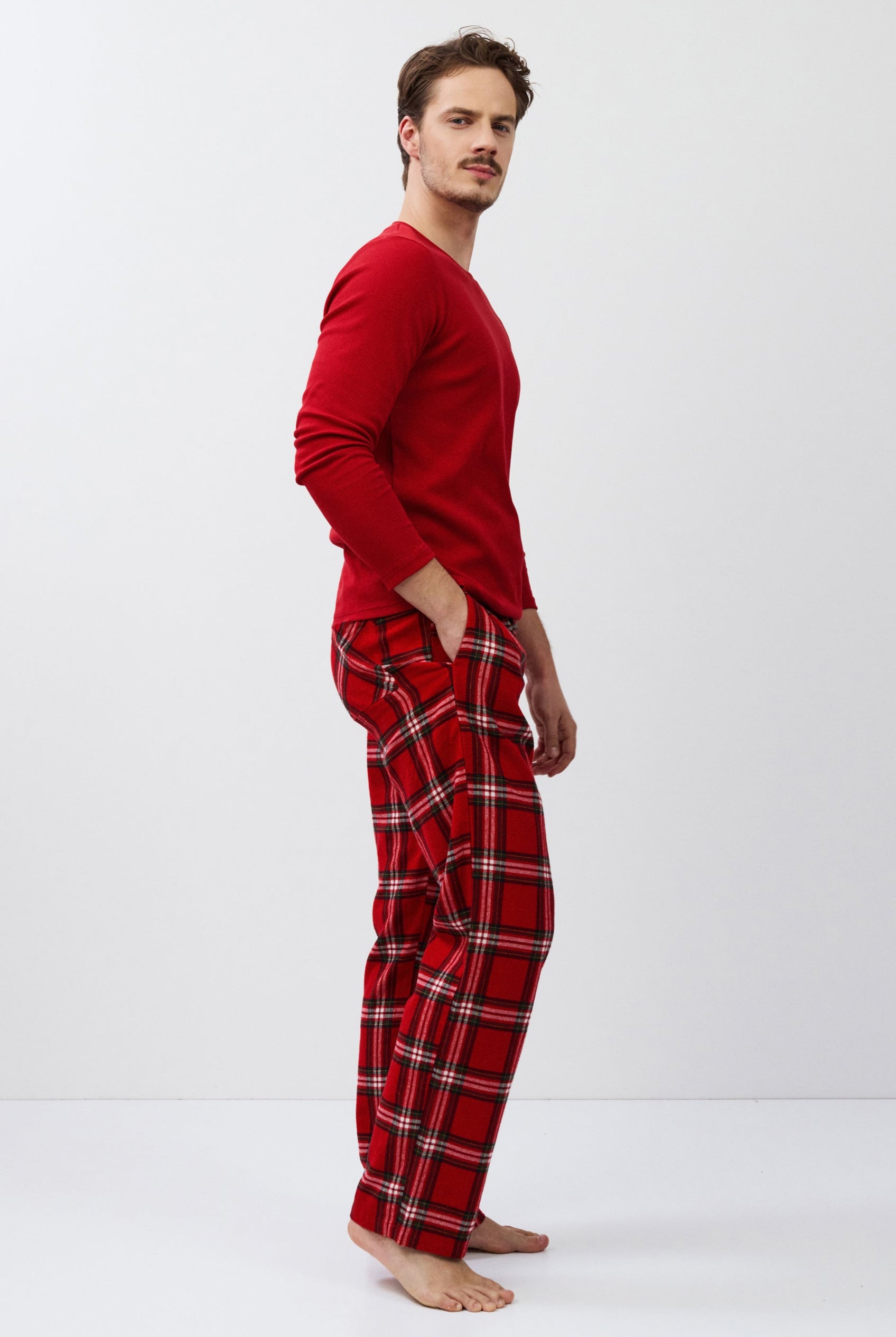Man wearing red plaid pajamas on a white background