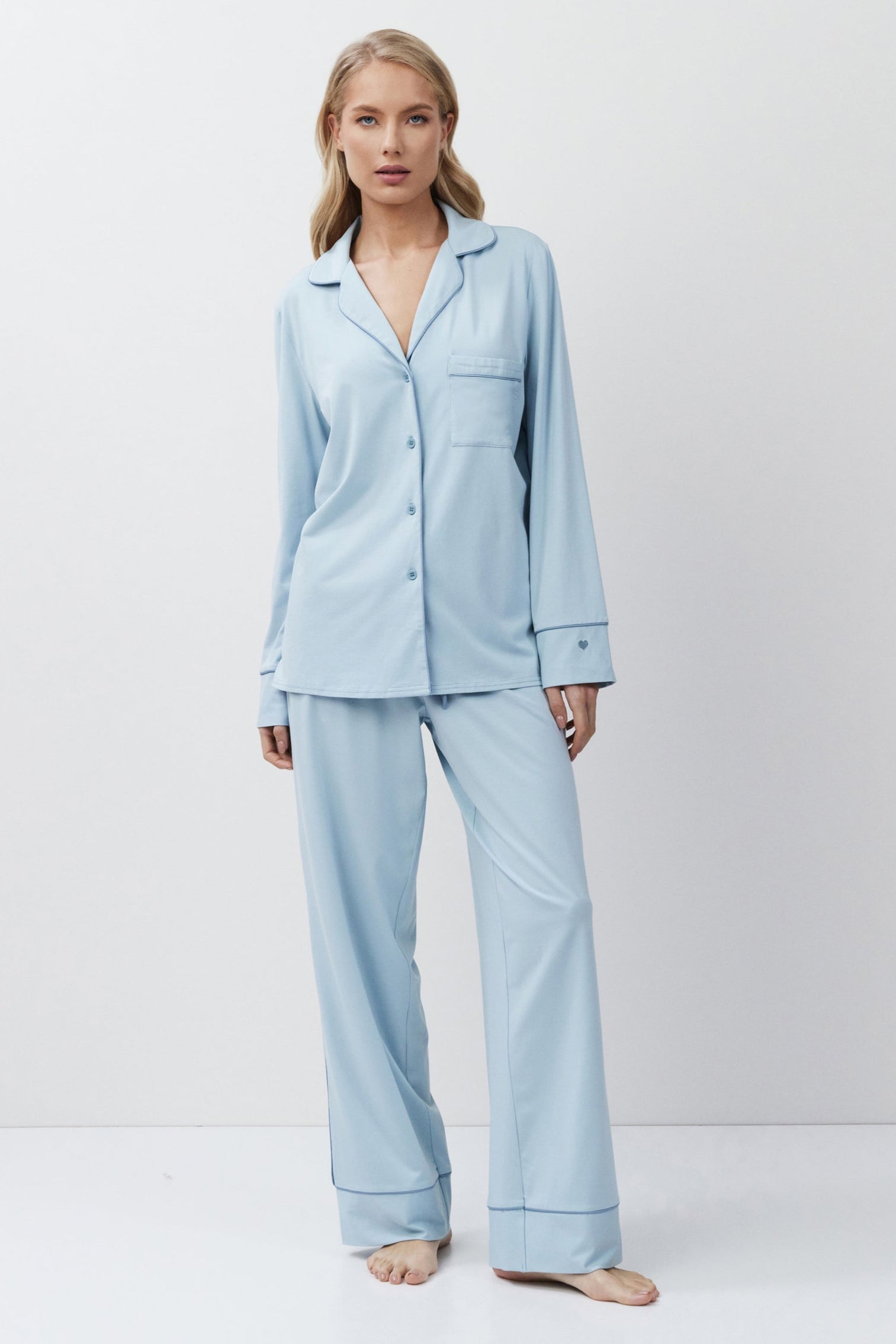 Woman wearing a light blue pajama set against a white background