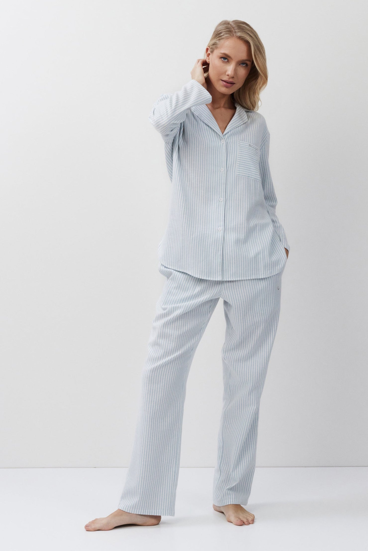 Woman wearing light blue pajamas on a white background