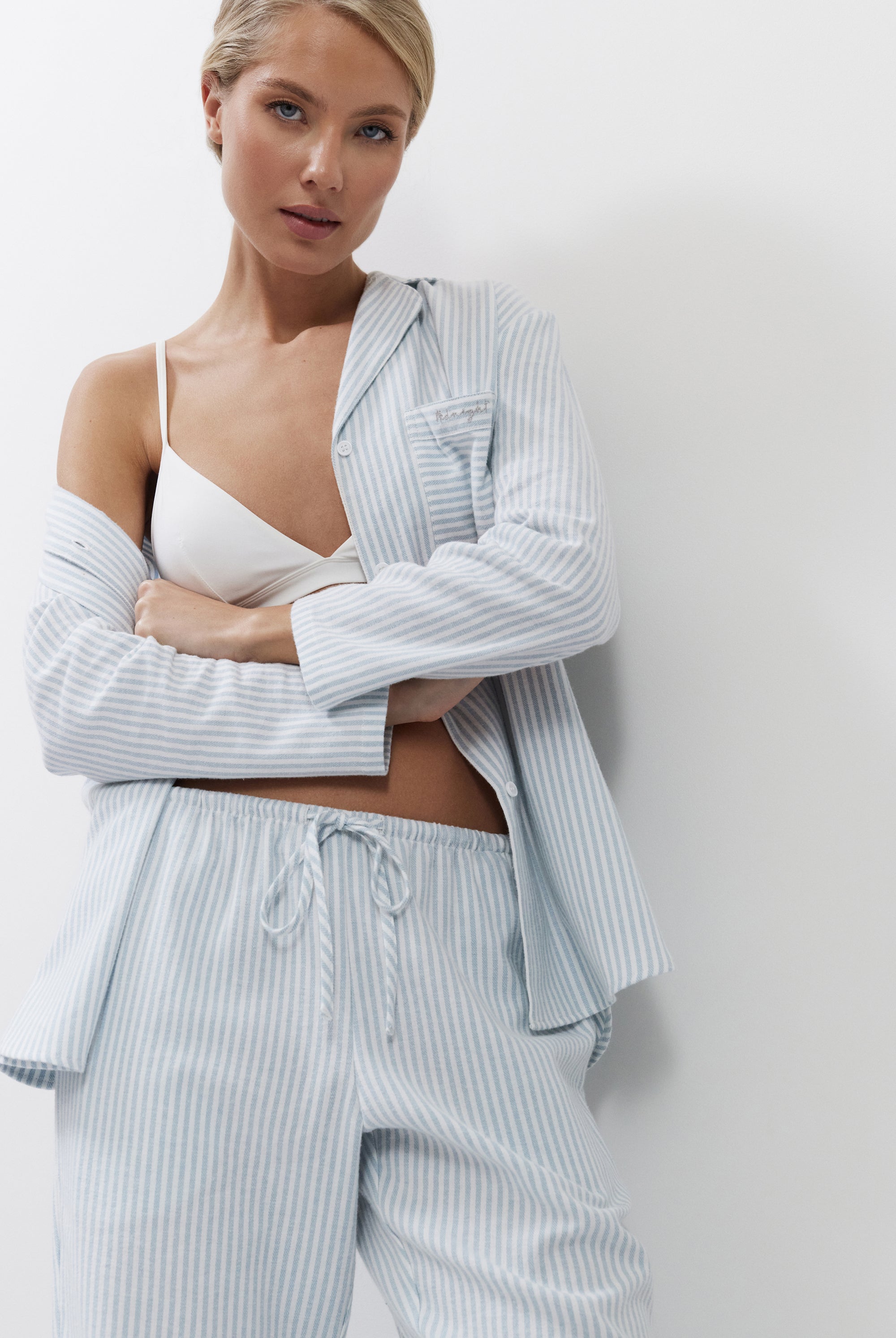 Woman wearing a light blue striped outfit against a white background