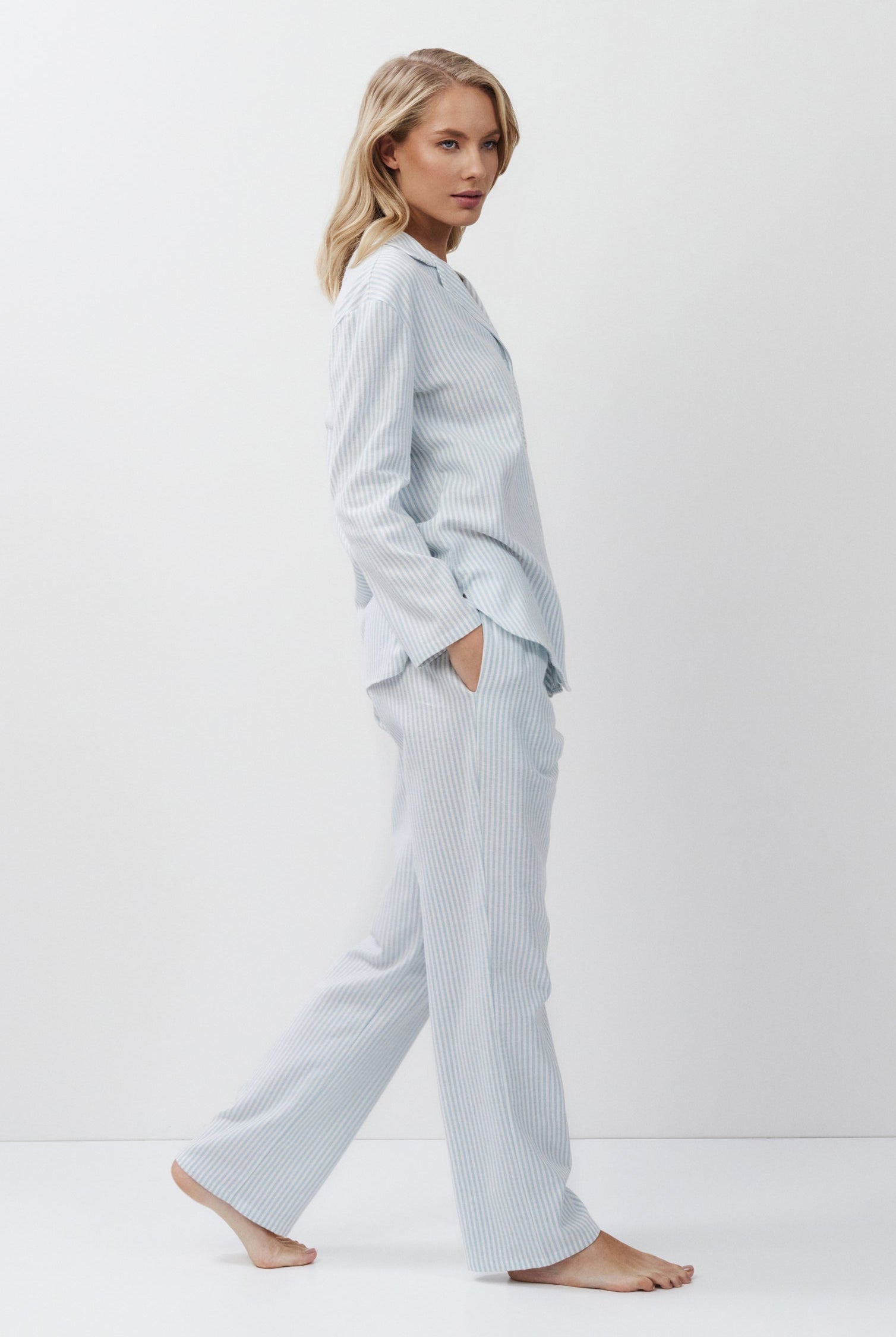 Woman wearing light blue pajamas on a white background