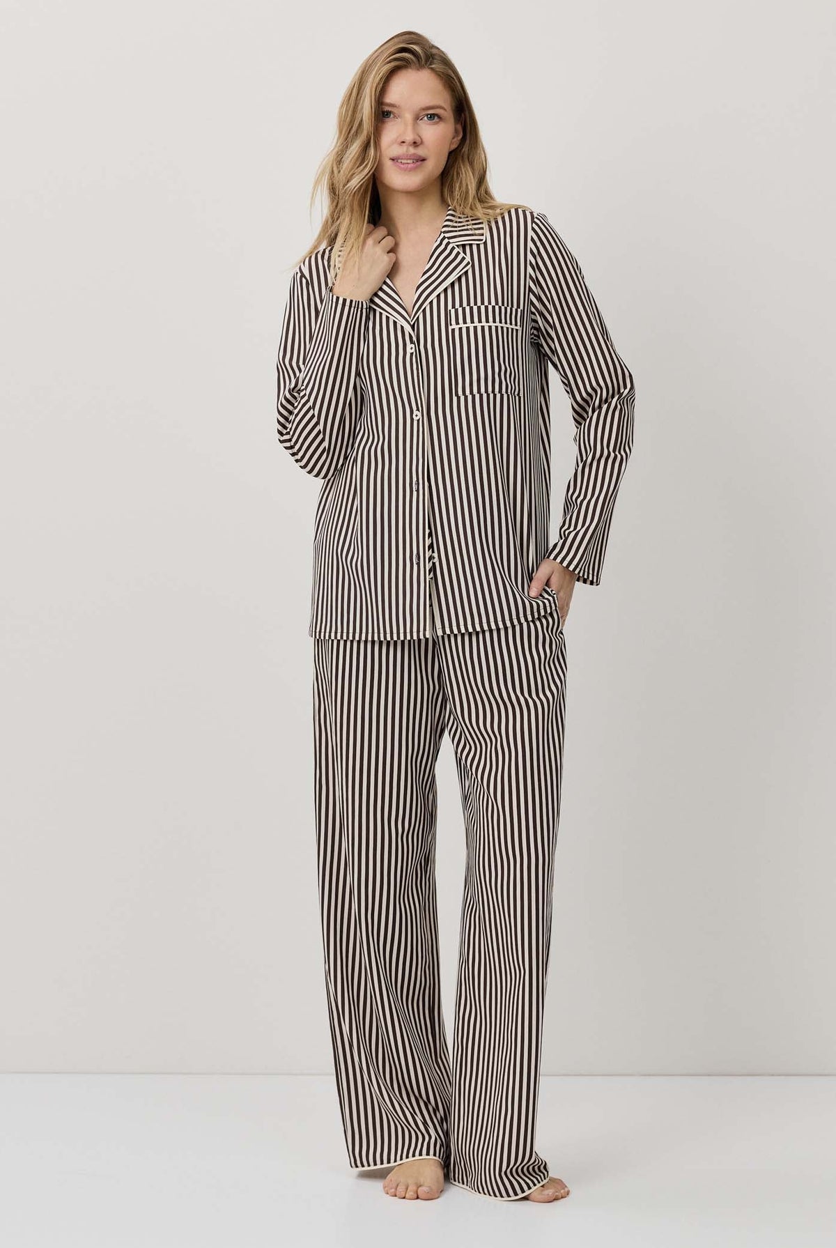 Woman wearing a striped pajama set on a white background