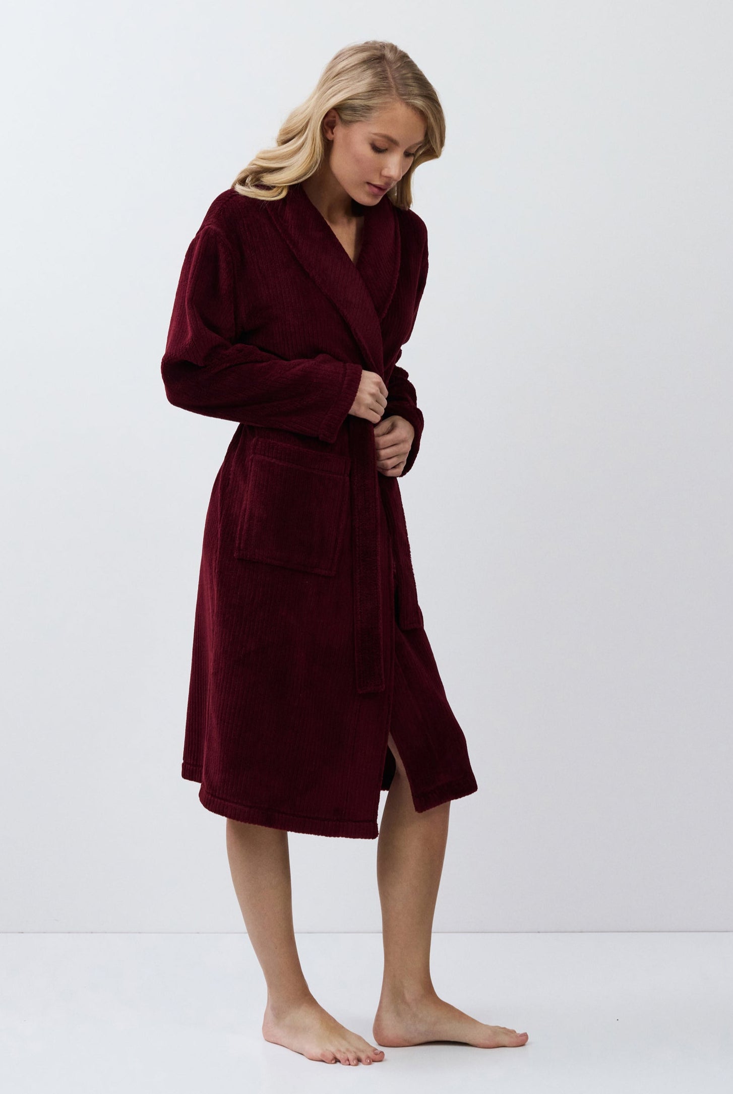 Person wearing a burgundy robe on a white background