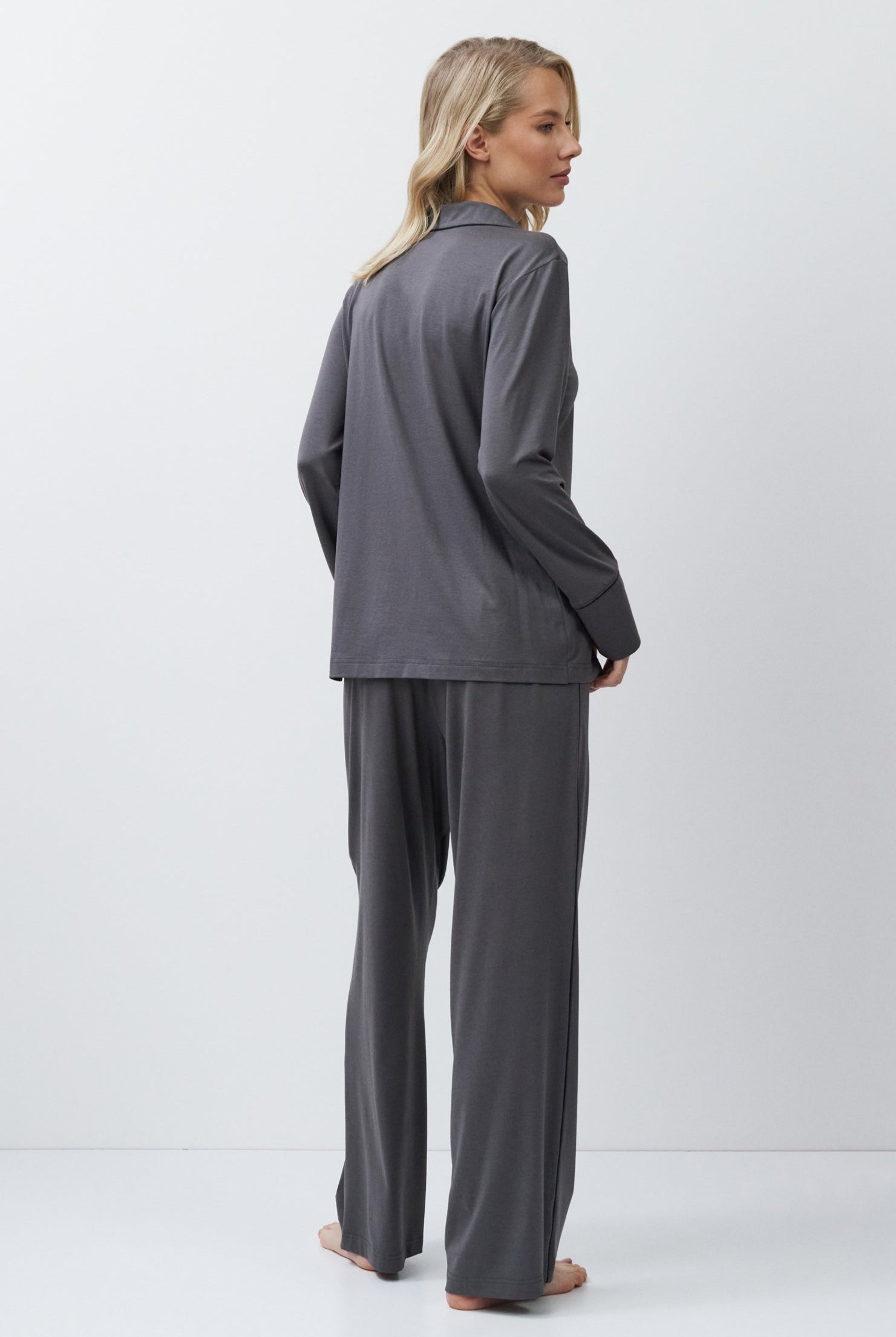 Person wearing a gray outfit on a white background