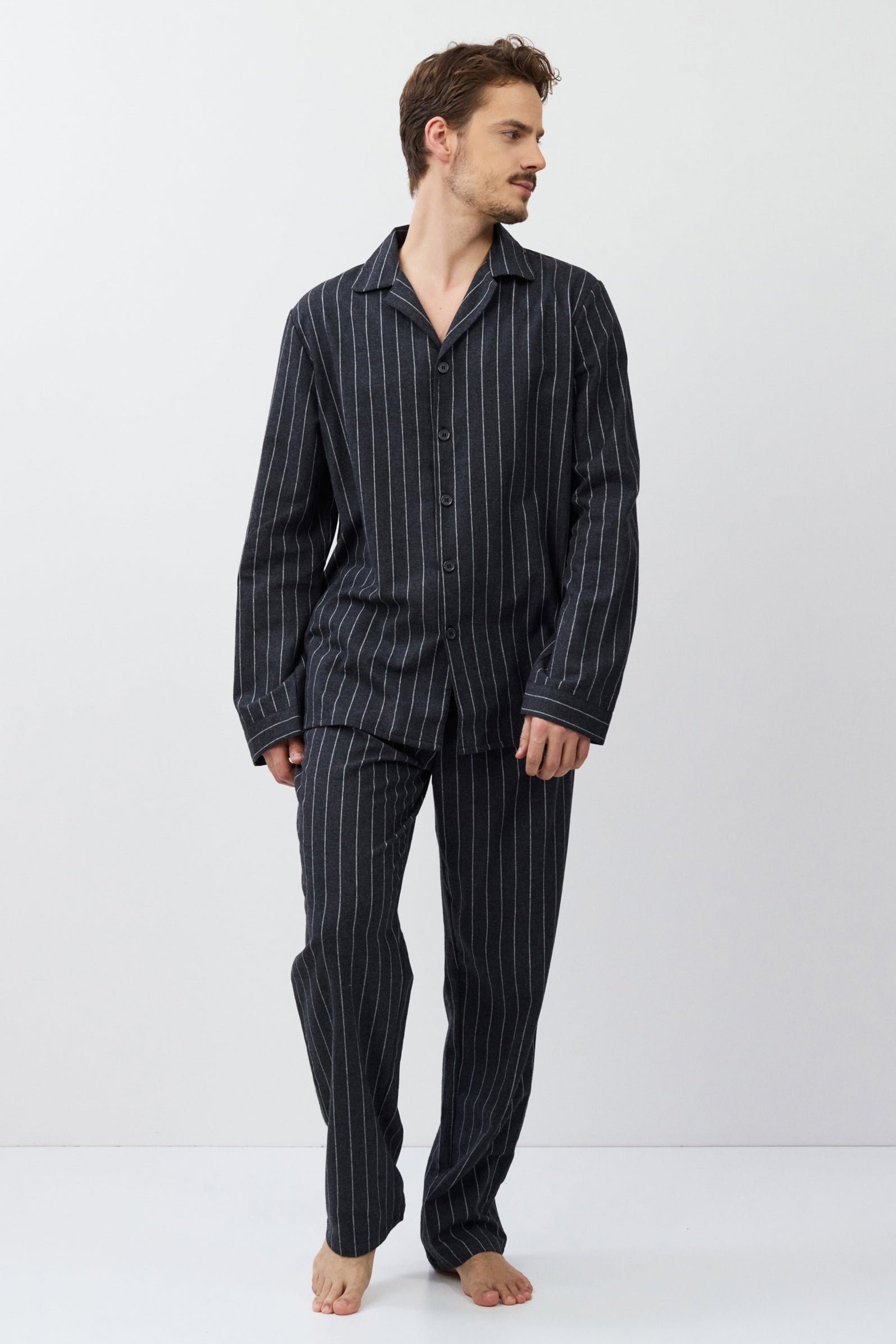Man wearing a striped pajama set on a white background