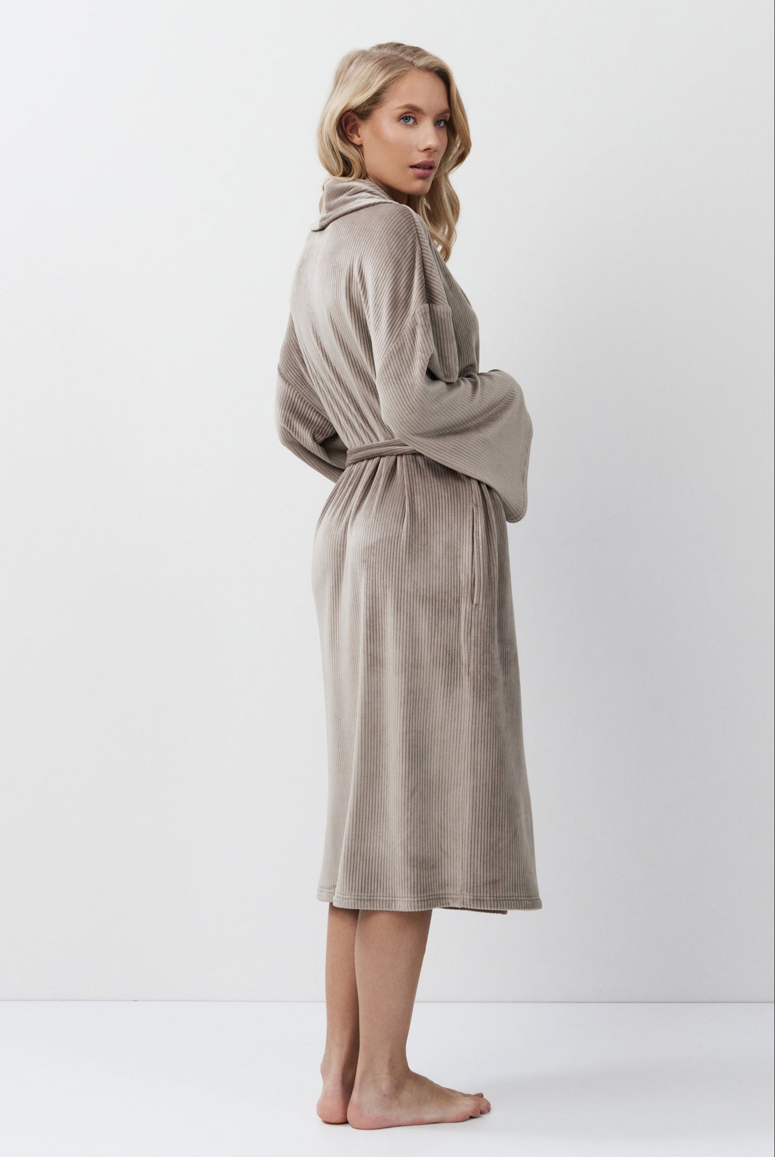 Woman wearing a capucine robe against a white background