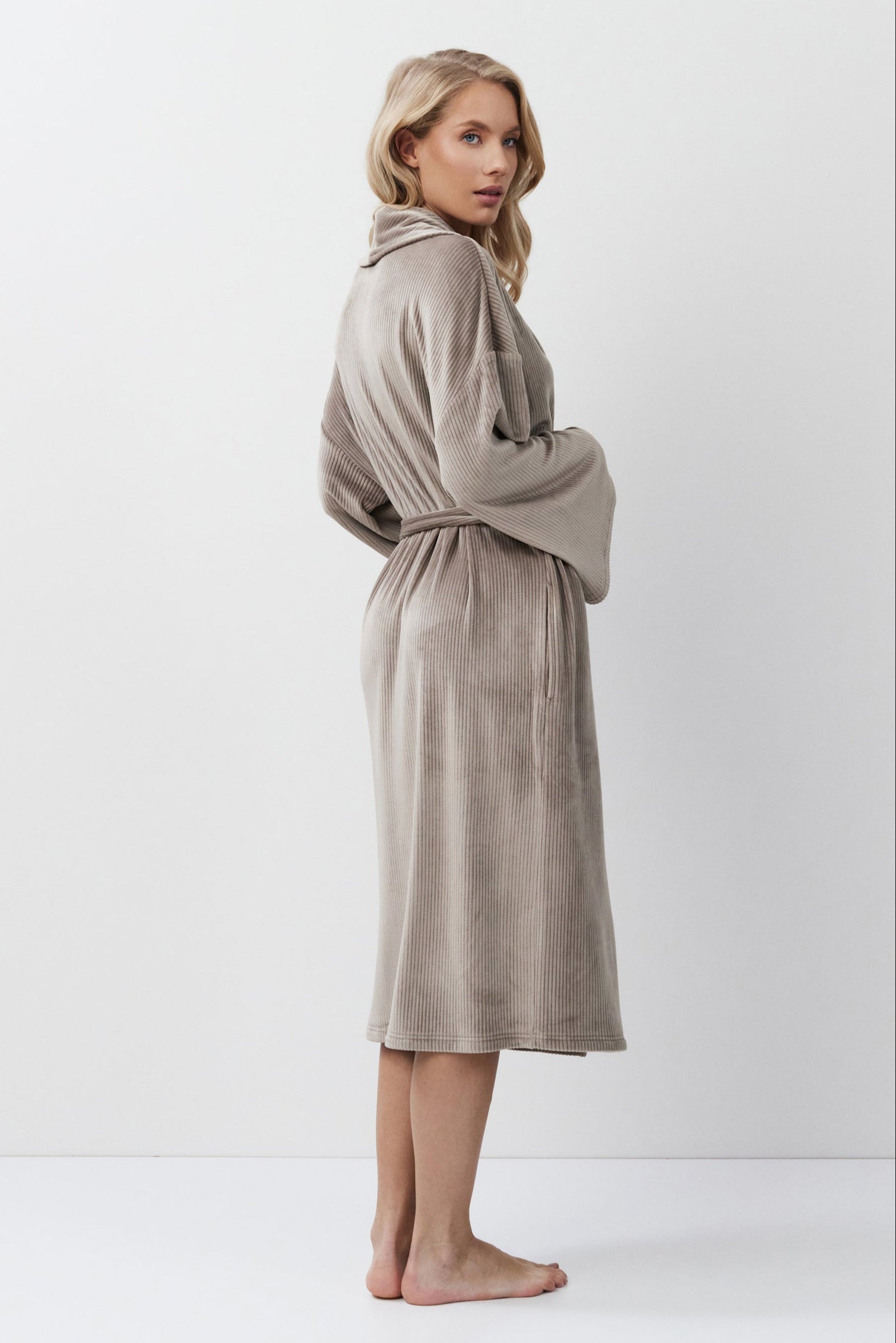 Woman wearing a capucine robe against a white background