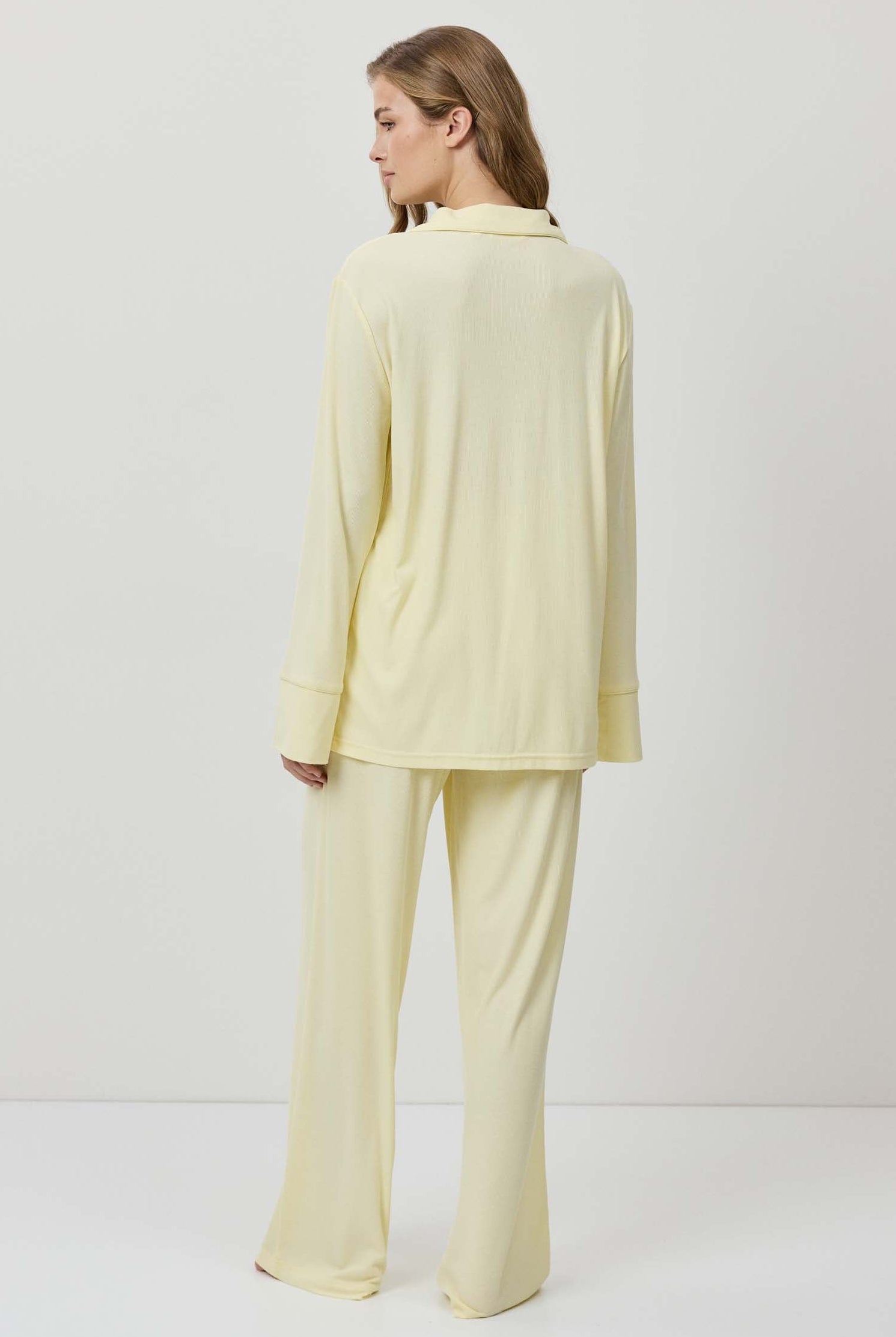 Woman wearing a light yellow outfit on a white background