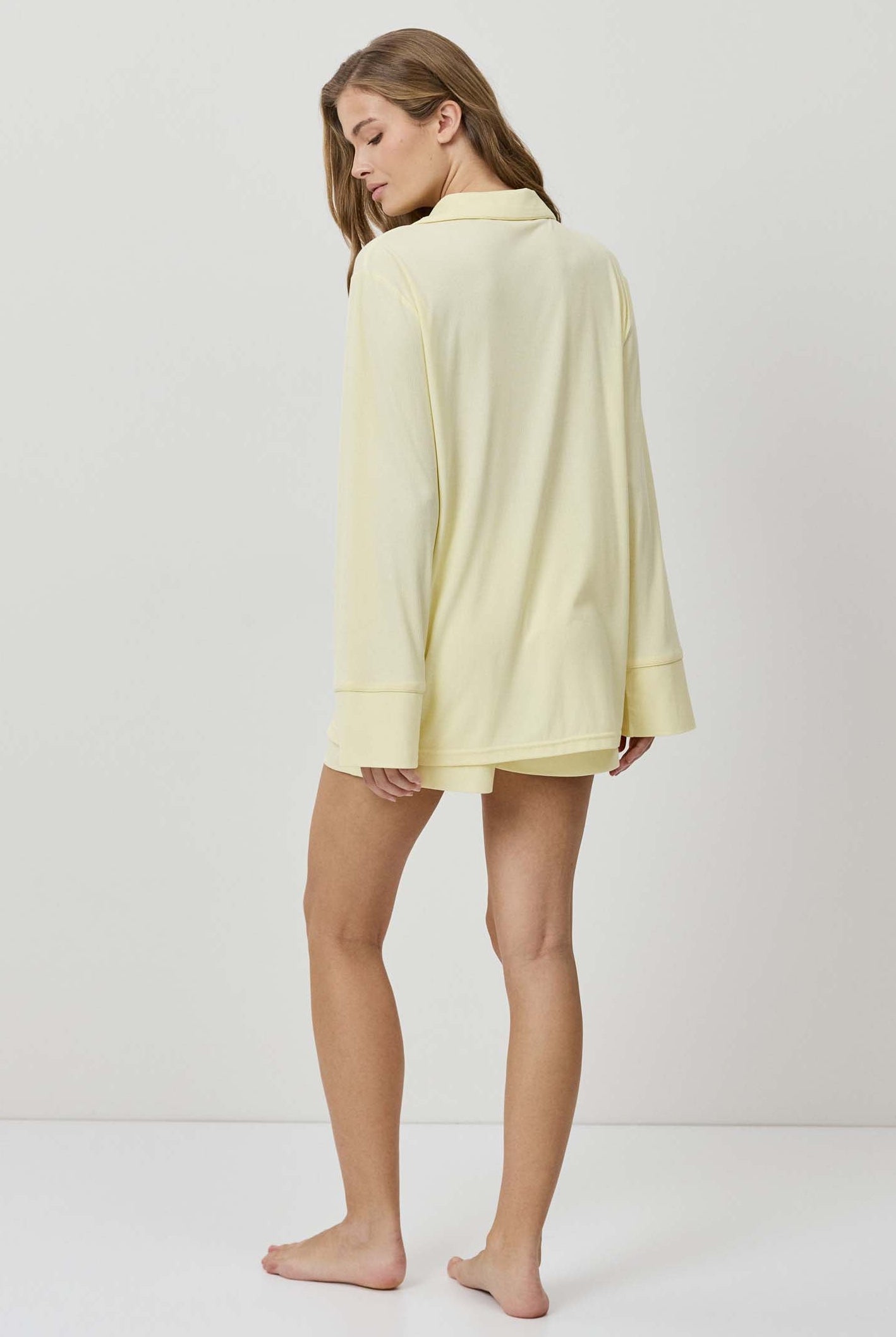 Woman wearing a light yellow dress against a white background