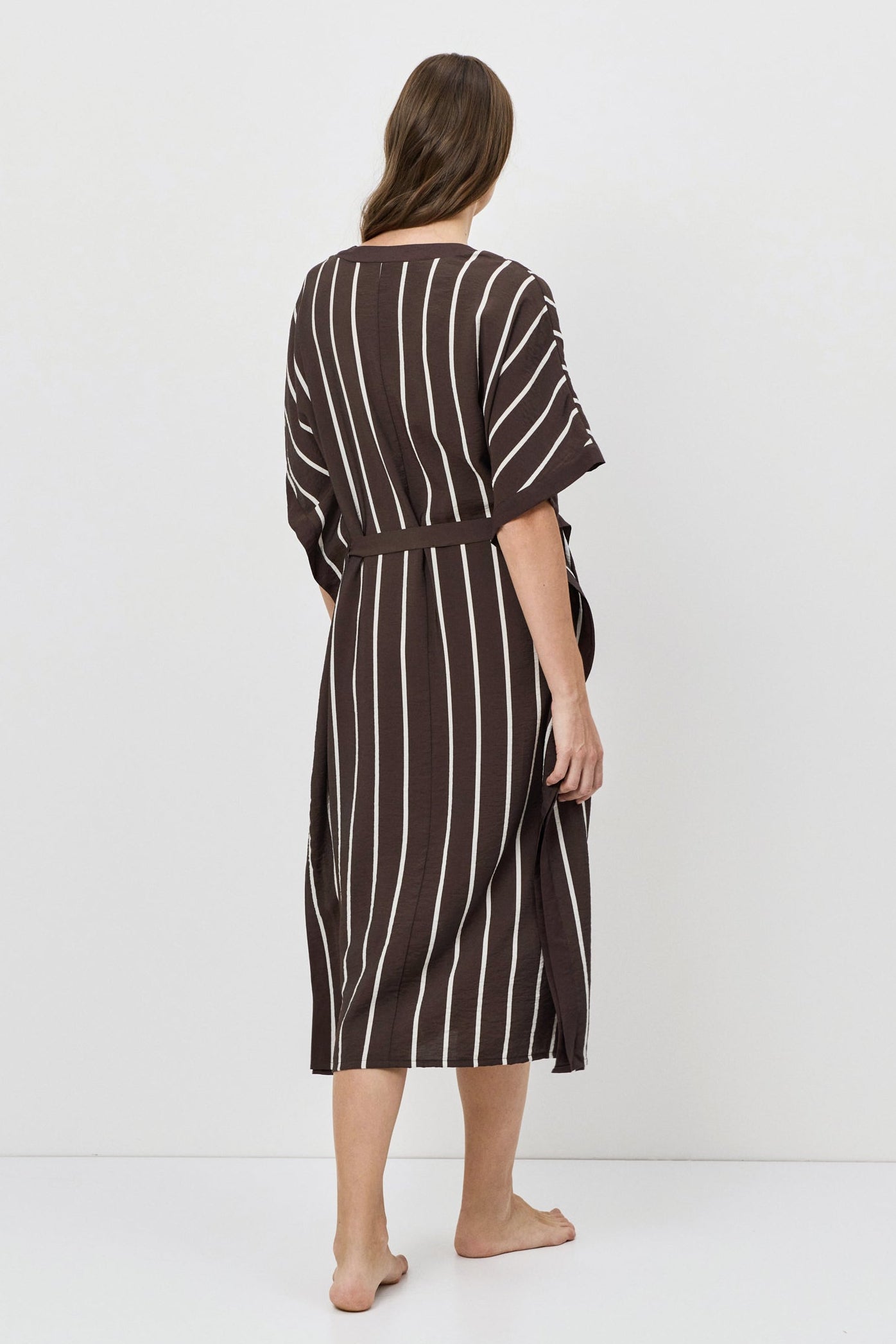 Woman wearing a striped dress on a white background