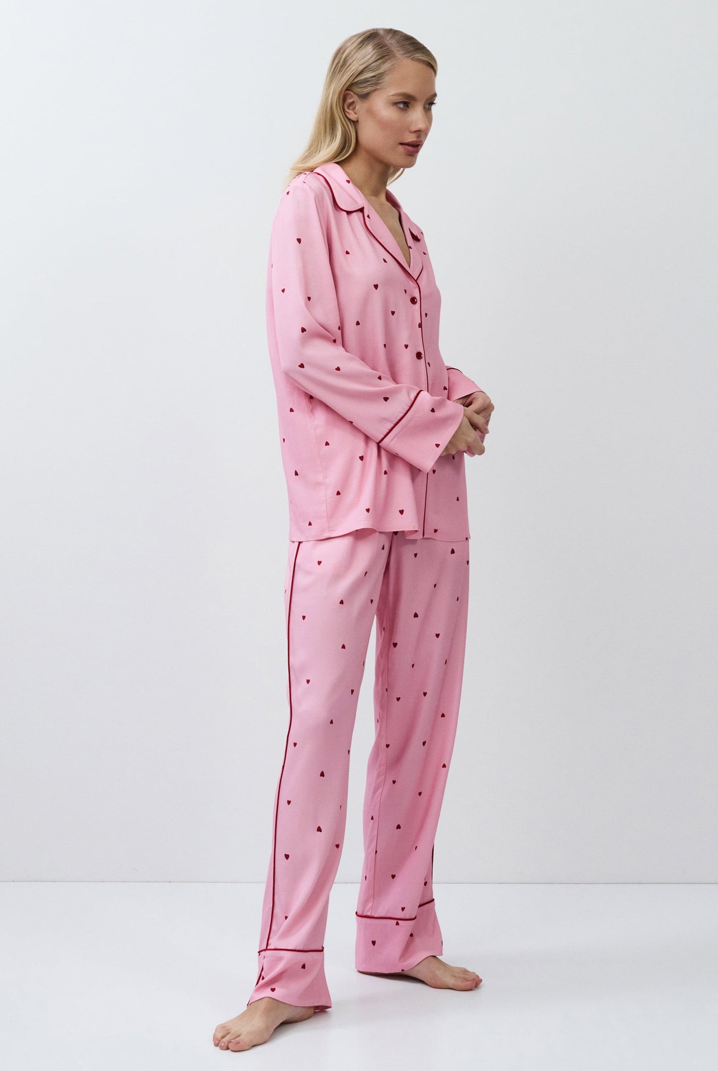 Woman wearing a pink pajama set with a white background
