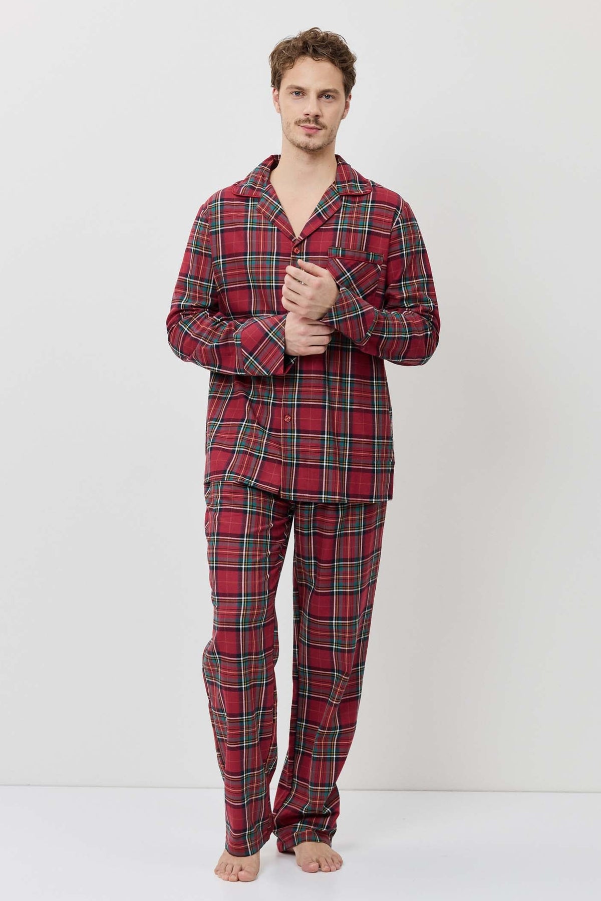 Man wearing red plaid pajama set on a white background