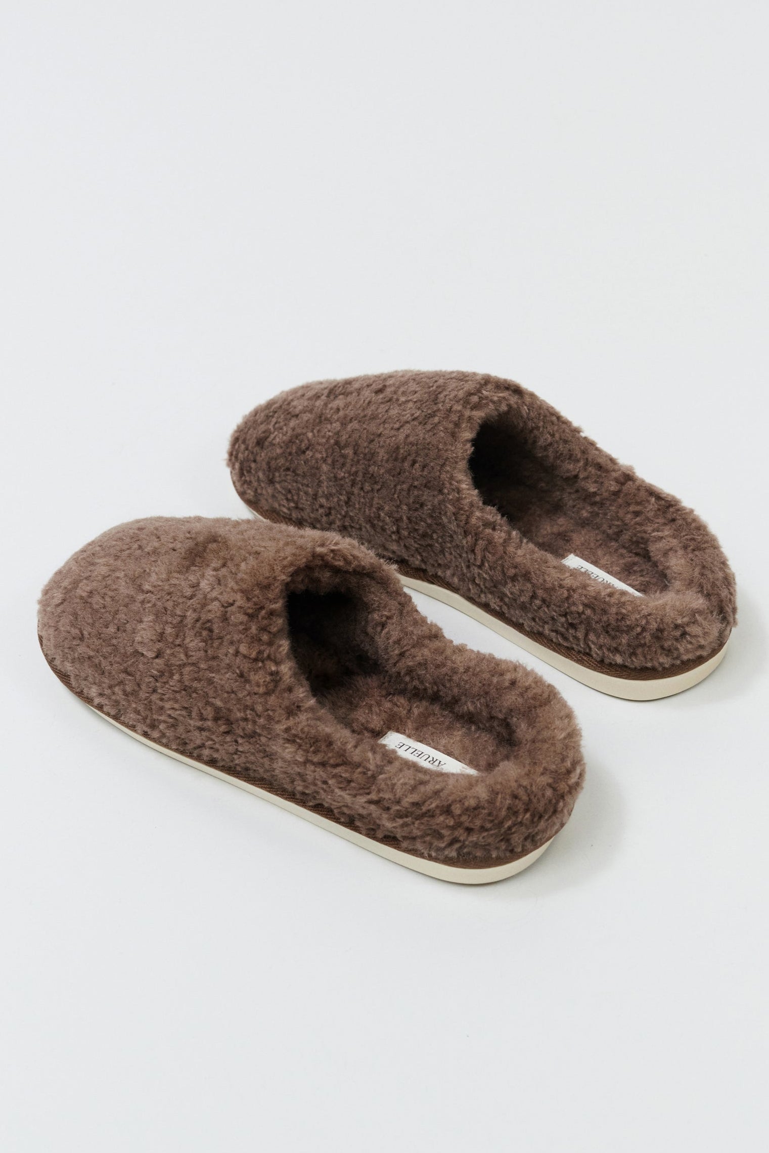 Pair of brown slippers on a light gray background