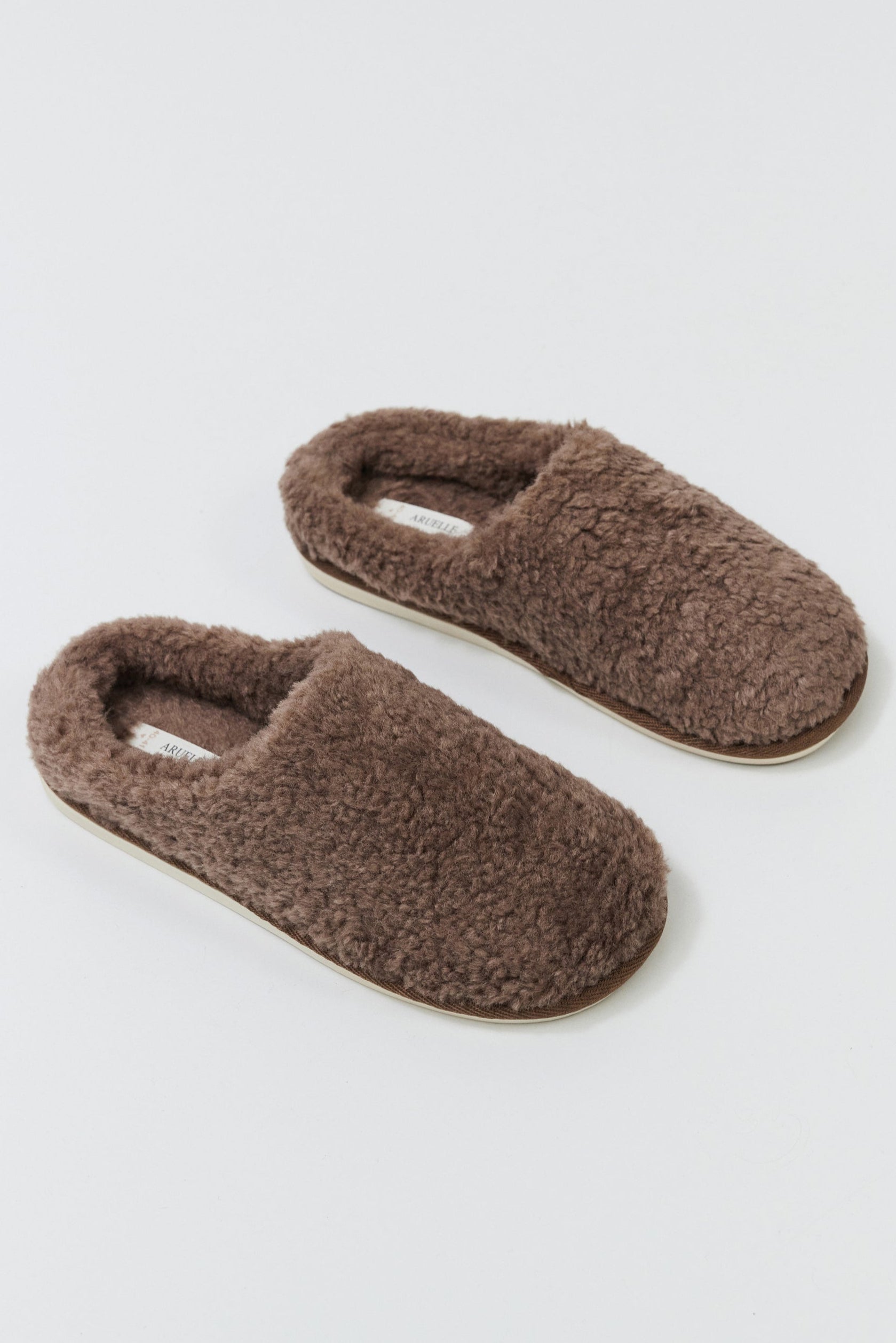 Pair of brown slippers on a light gray background