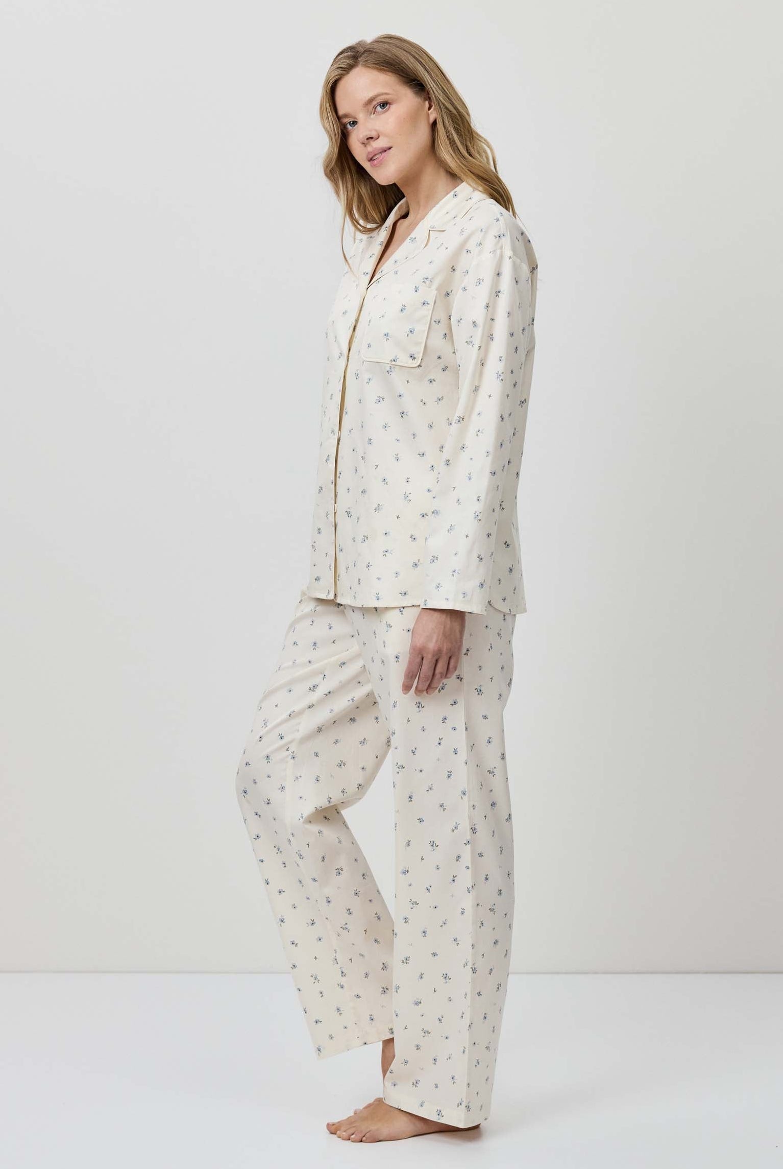 Woman wearing a white pajama set with a subtle pattern on a white background