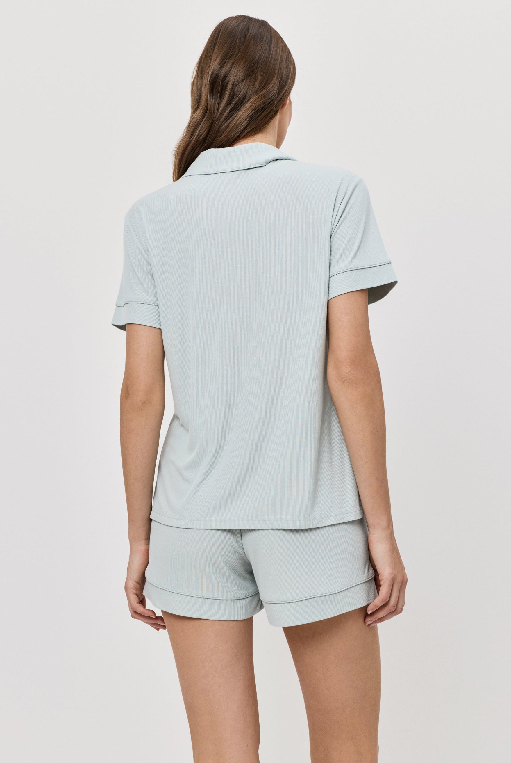 Woman wearing a light blue pajama set on a white background