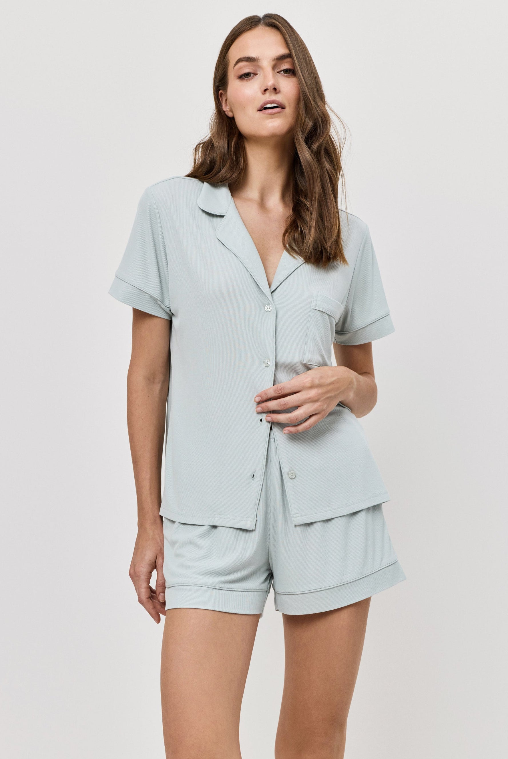 Woman wearing a light blue pajama set against a white background