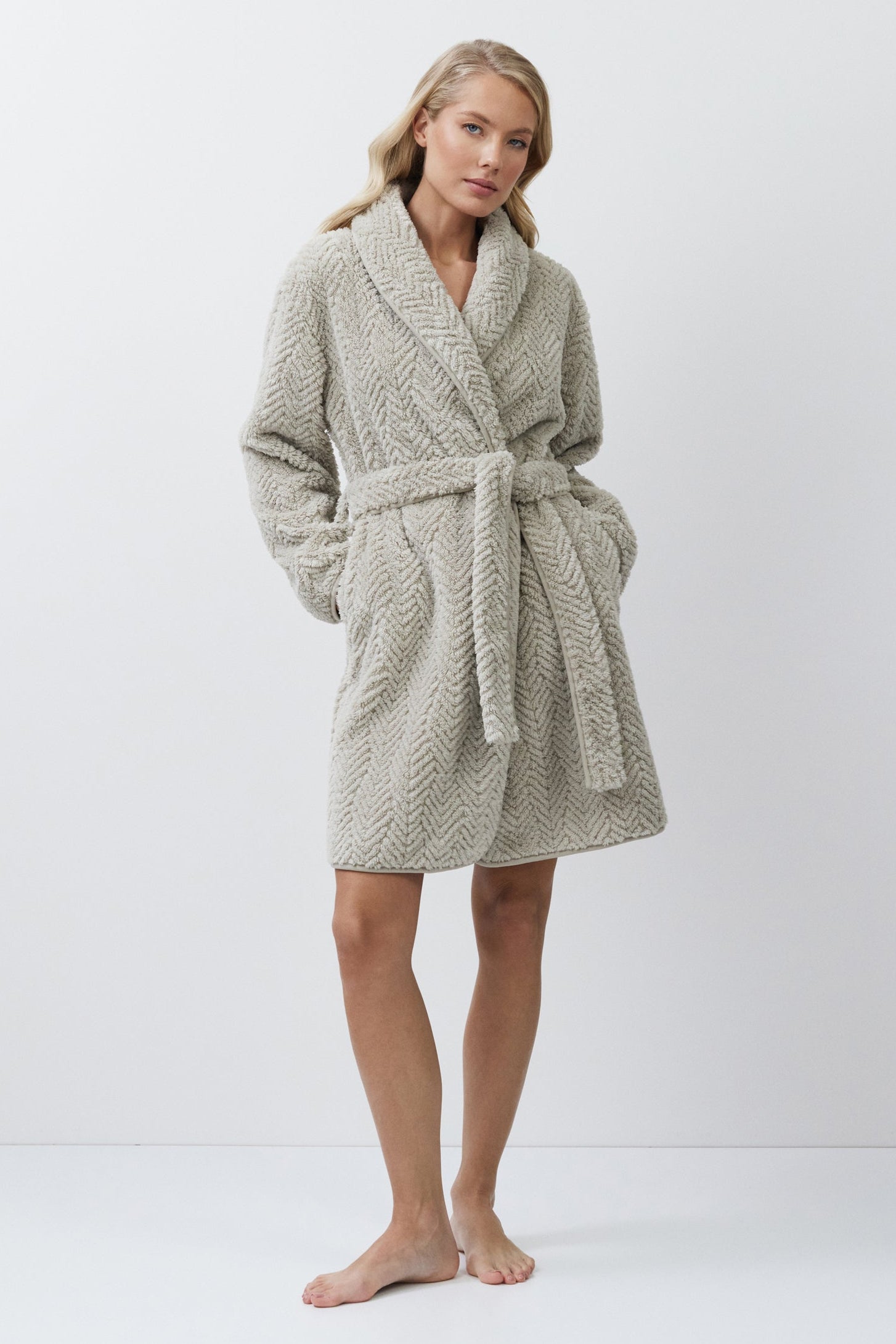 Woman wearing a beige bathrobe on a white background