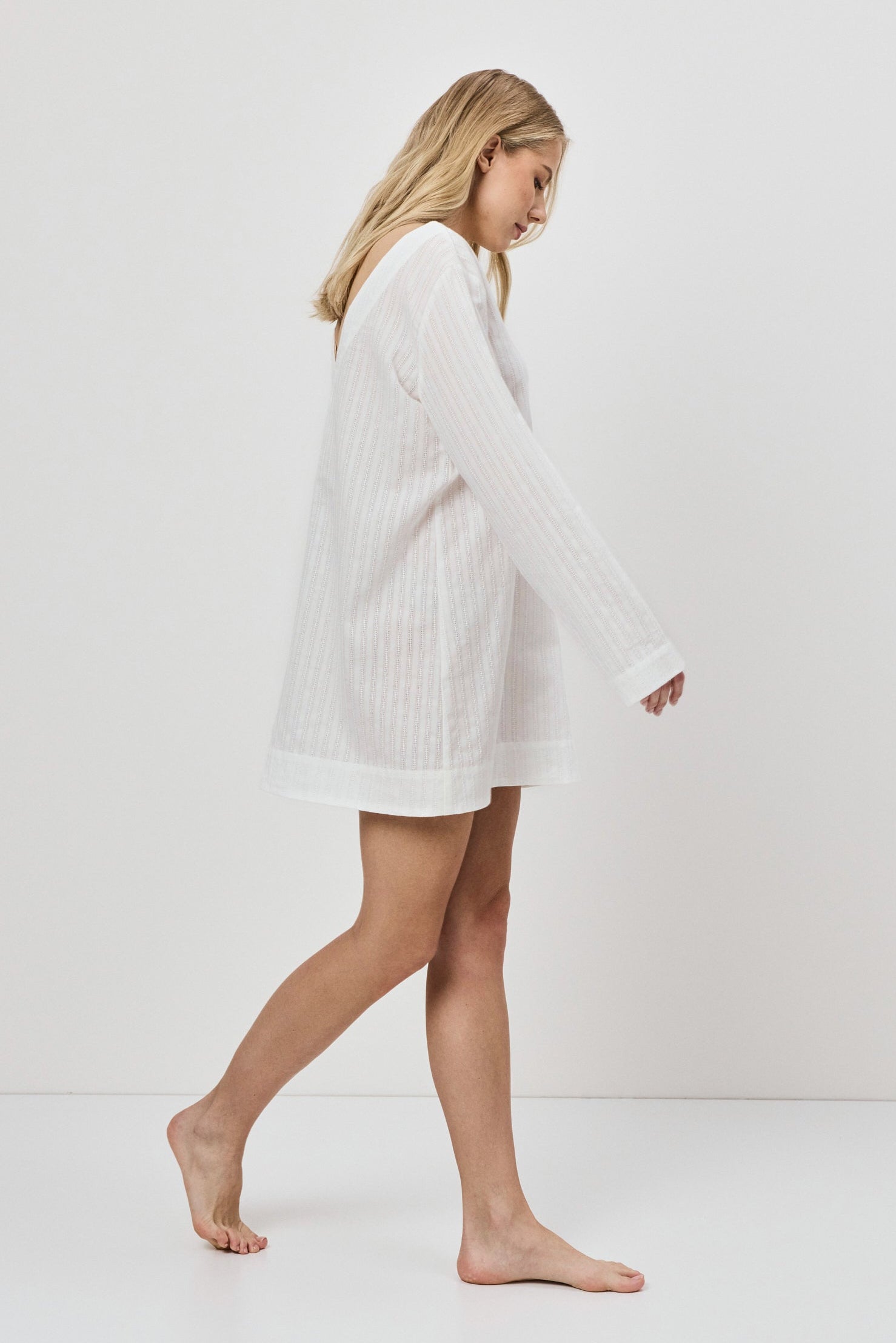 Woman wearing a white dress on a plain background