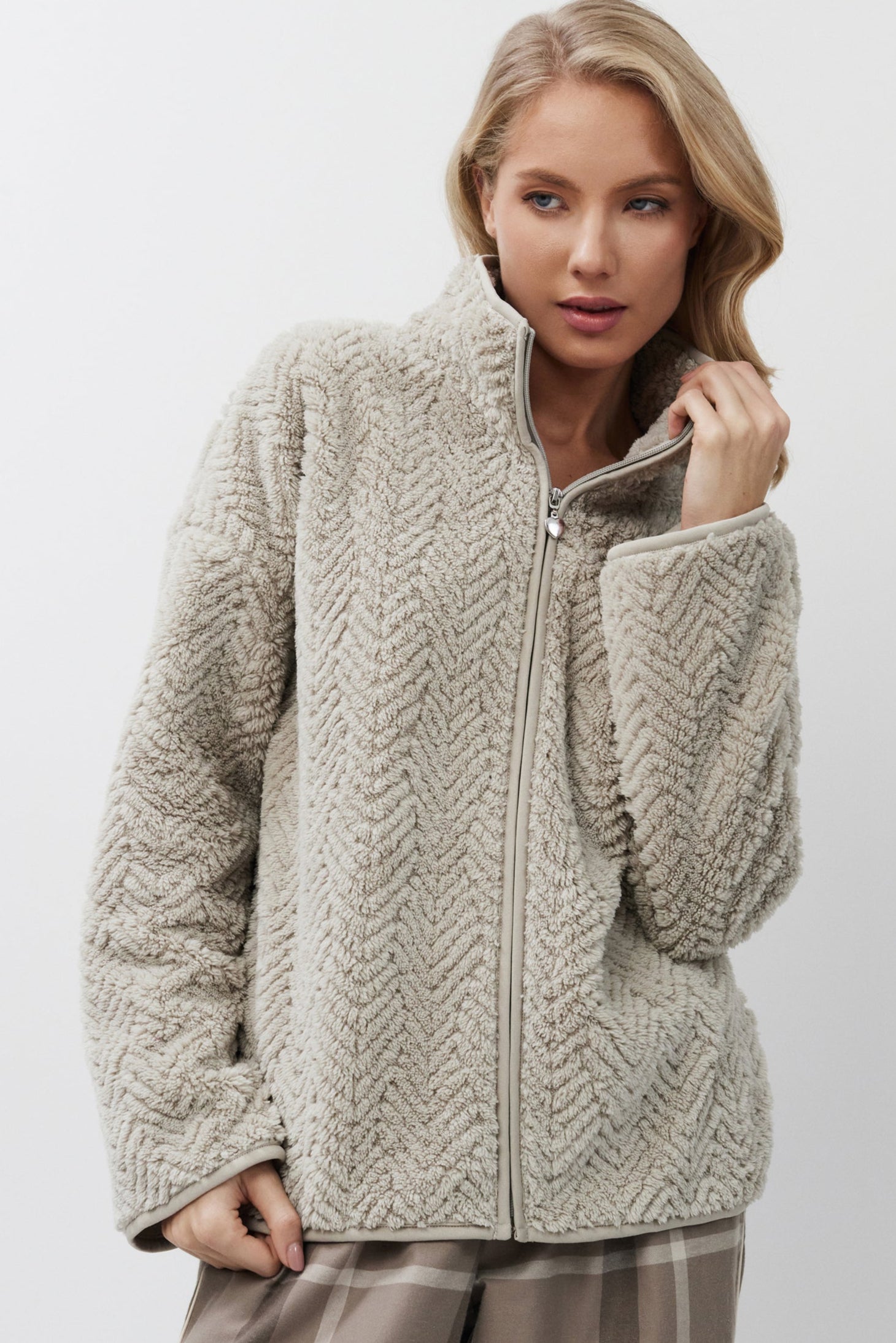 Woman wearing a beige jacket on a white background