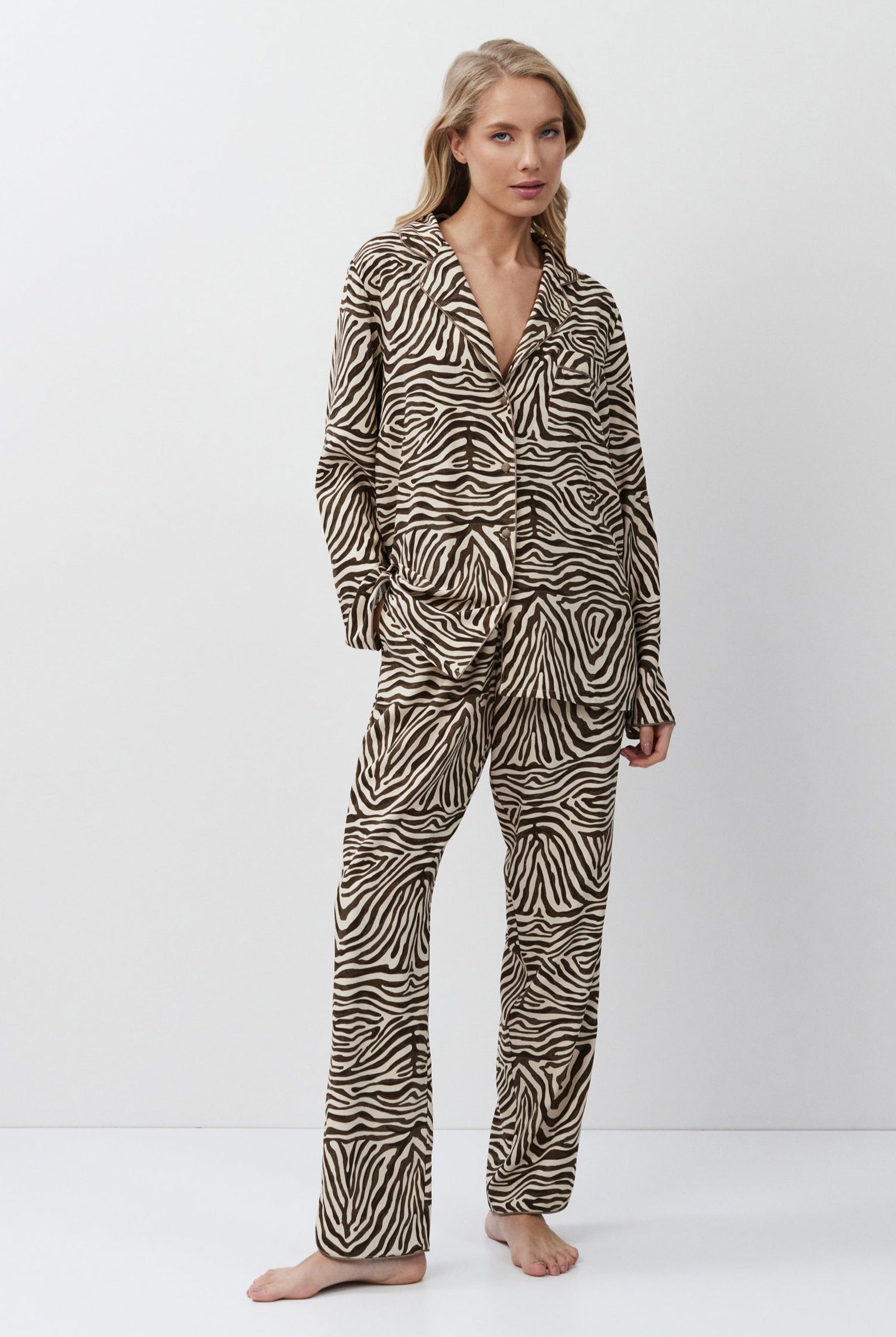 Woman wearing a zebra print pajama set on a white background