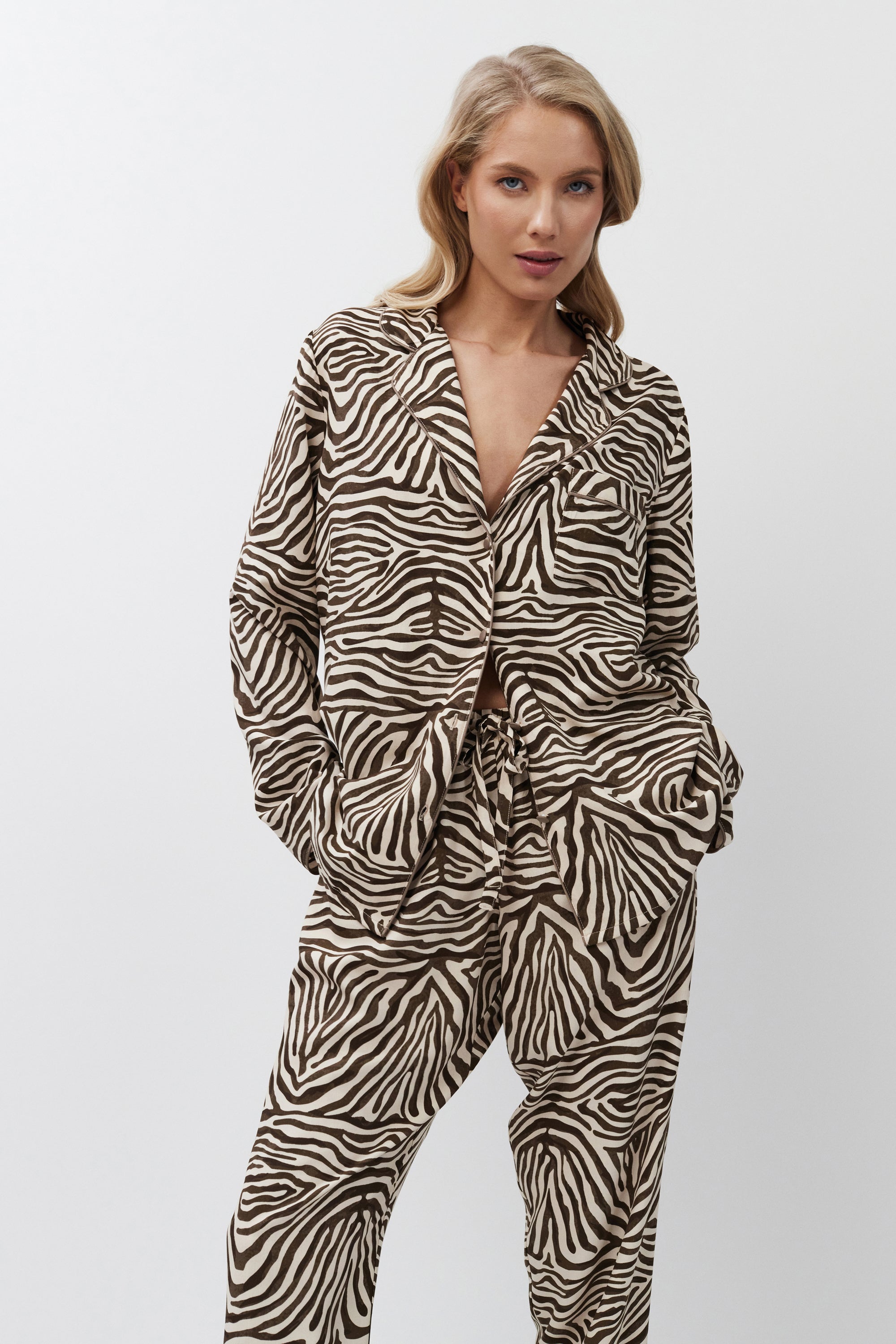 Woman wearing a zebra print jumpsuit on a white background