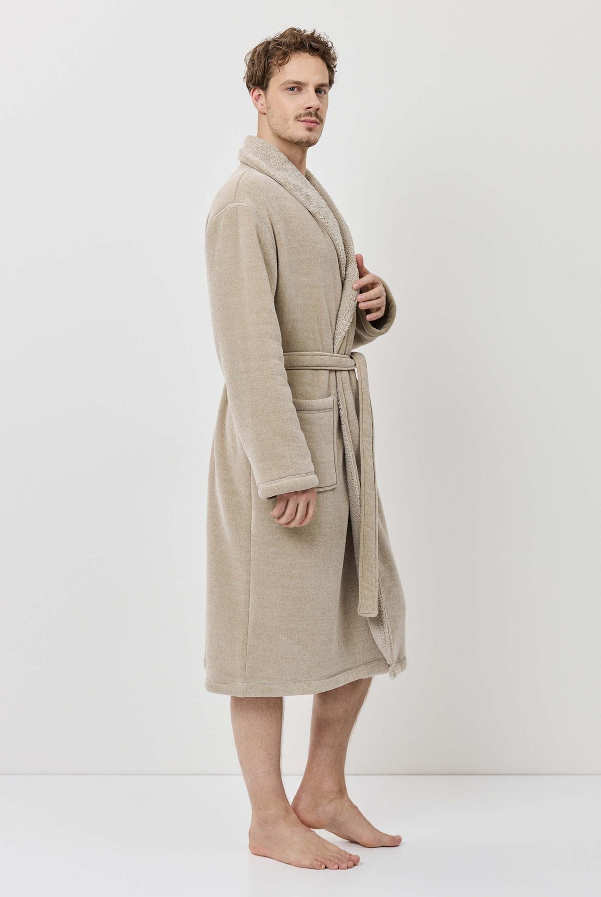 Man wearing a beige robe against a white background
