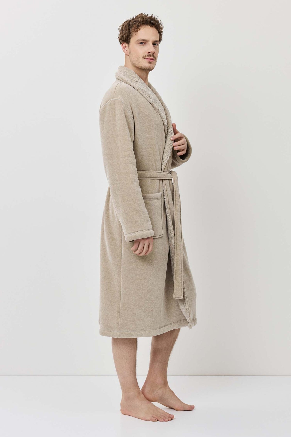 Man wearing a beige robe against a white background