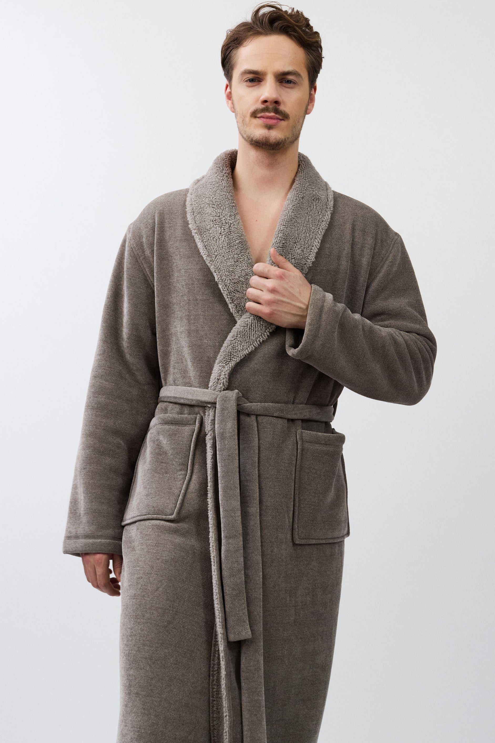Man wearing a brown robe against a white background