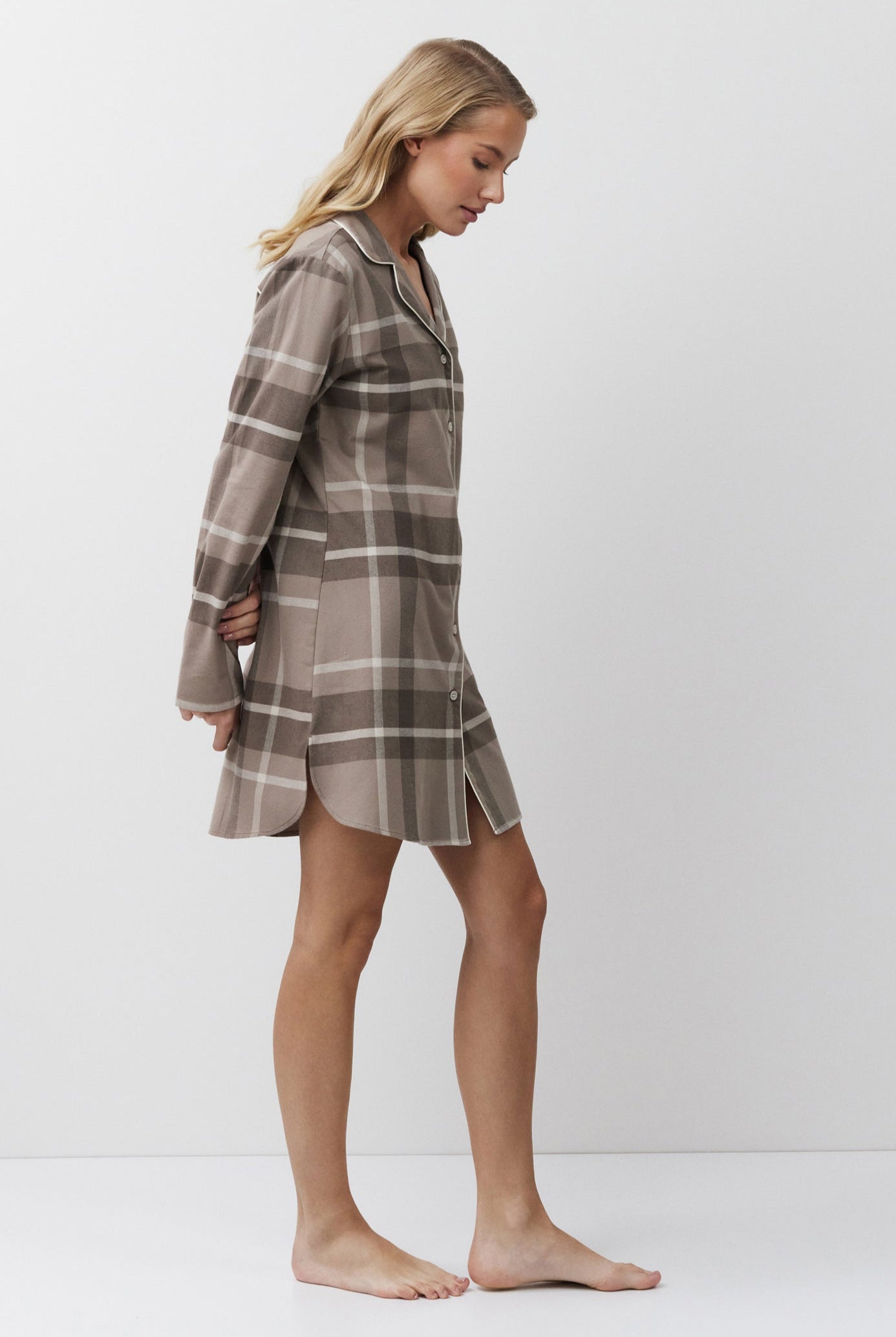 Woman wearing a plaid nightdress against a white background