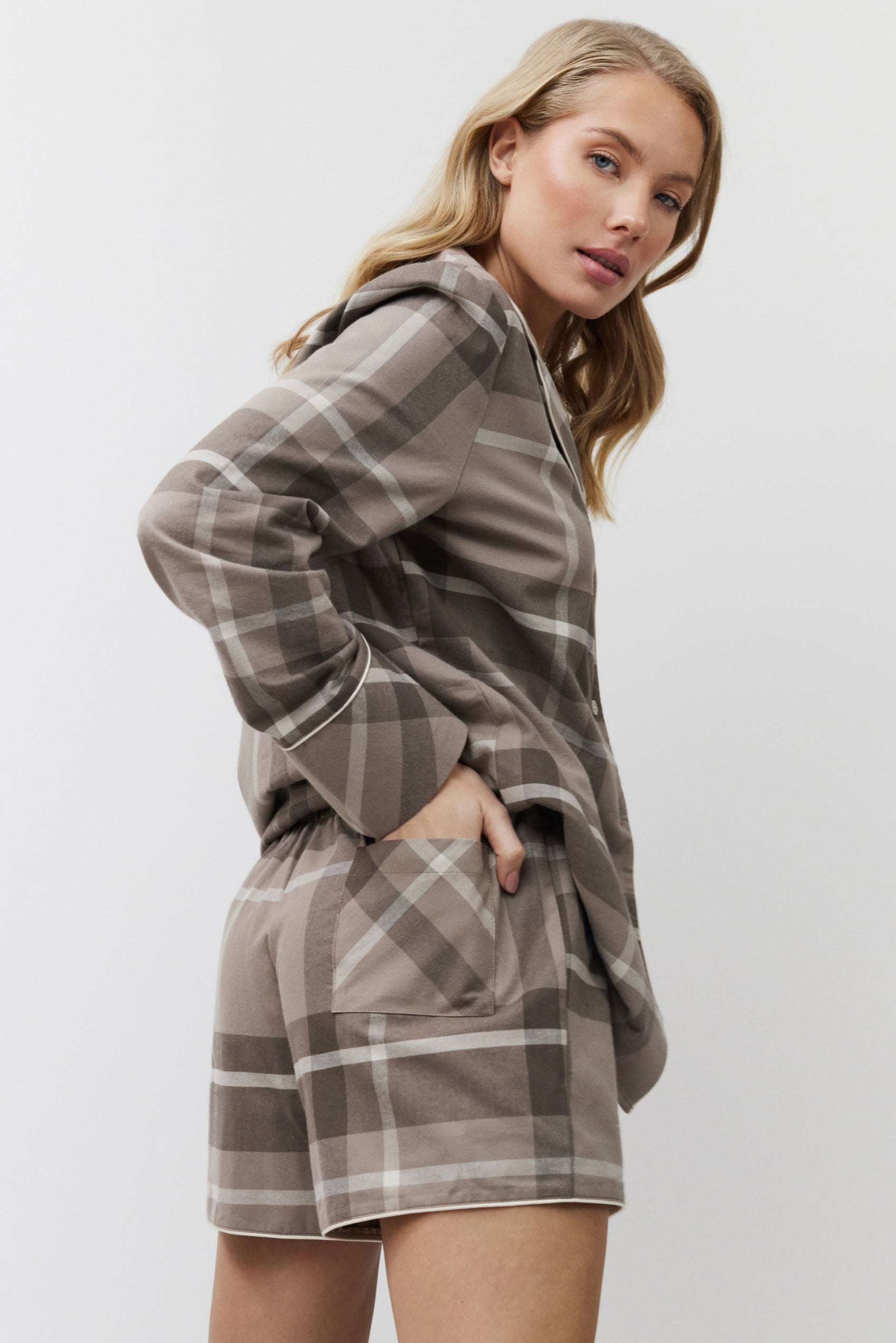 Woman wearing a plaid pajama set on a white background