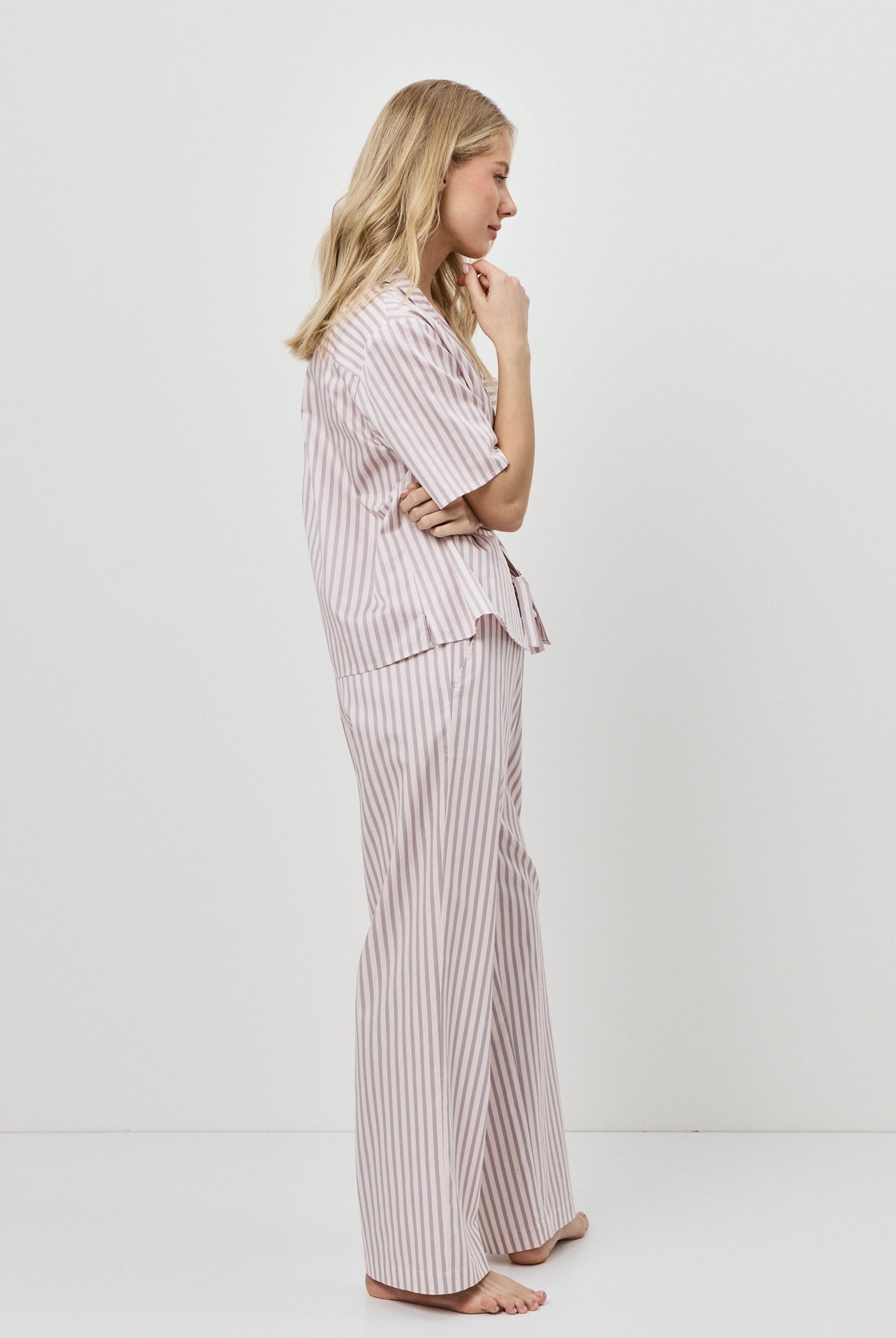Woman wearing a striped pajama set on a white background