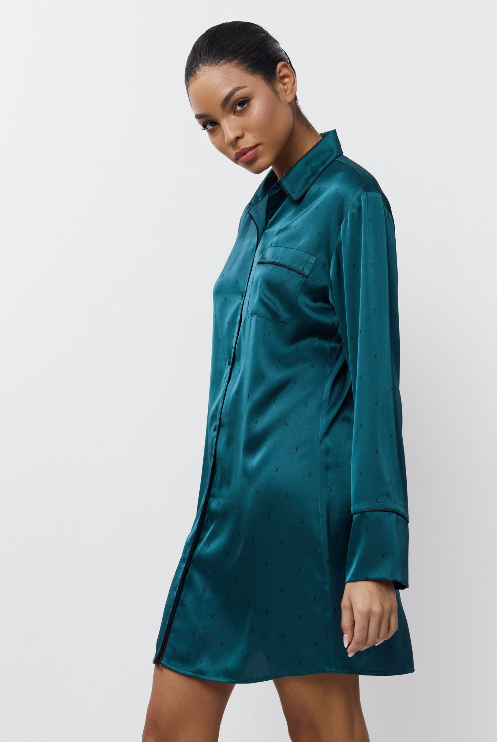 Woman wearing a satin shirt nightdress against a white background