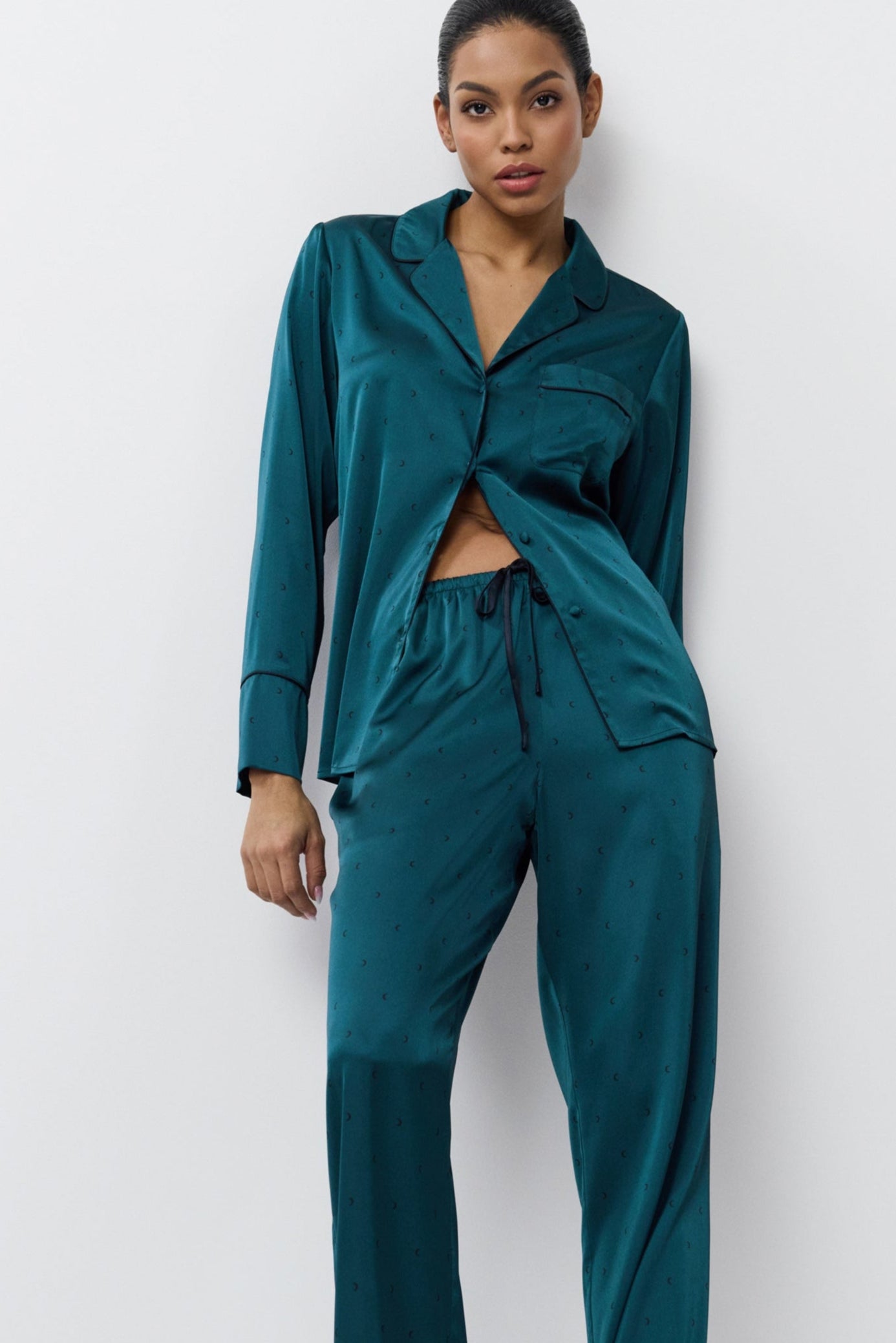 Woman wearing a satin pajama set against a white background