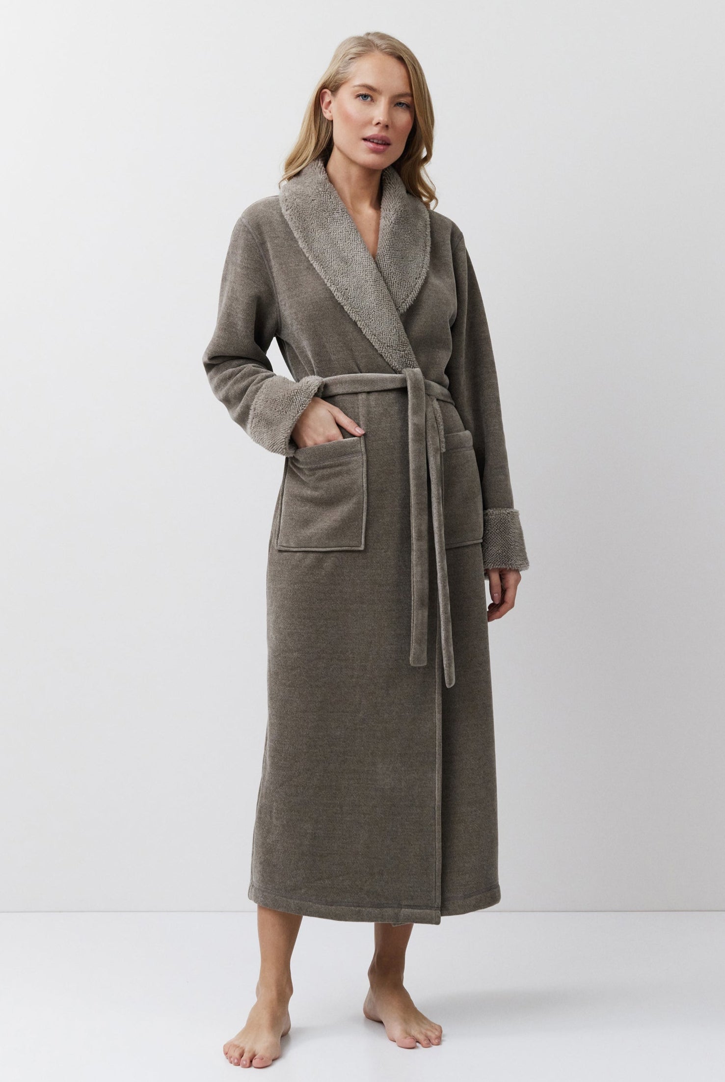 Woman wearing a long brown bathrobe on a white background