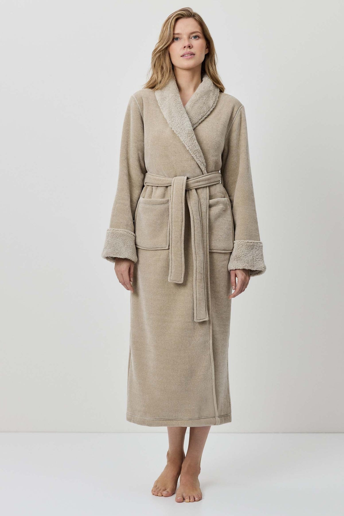 Woman wearing a beige robe against a white background