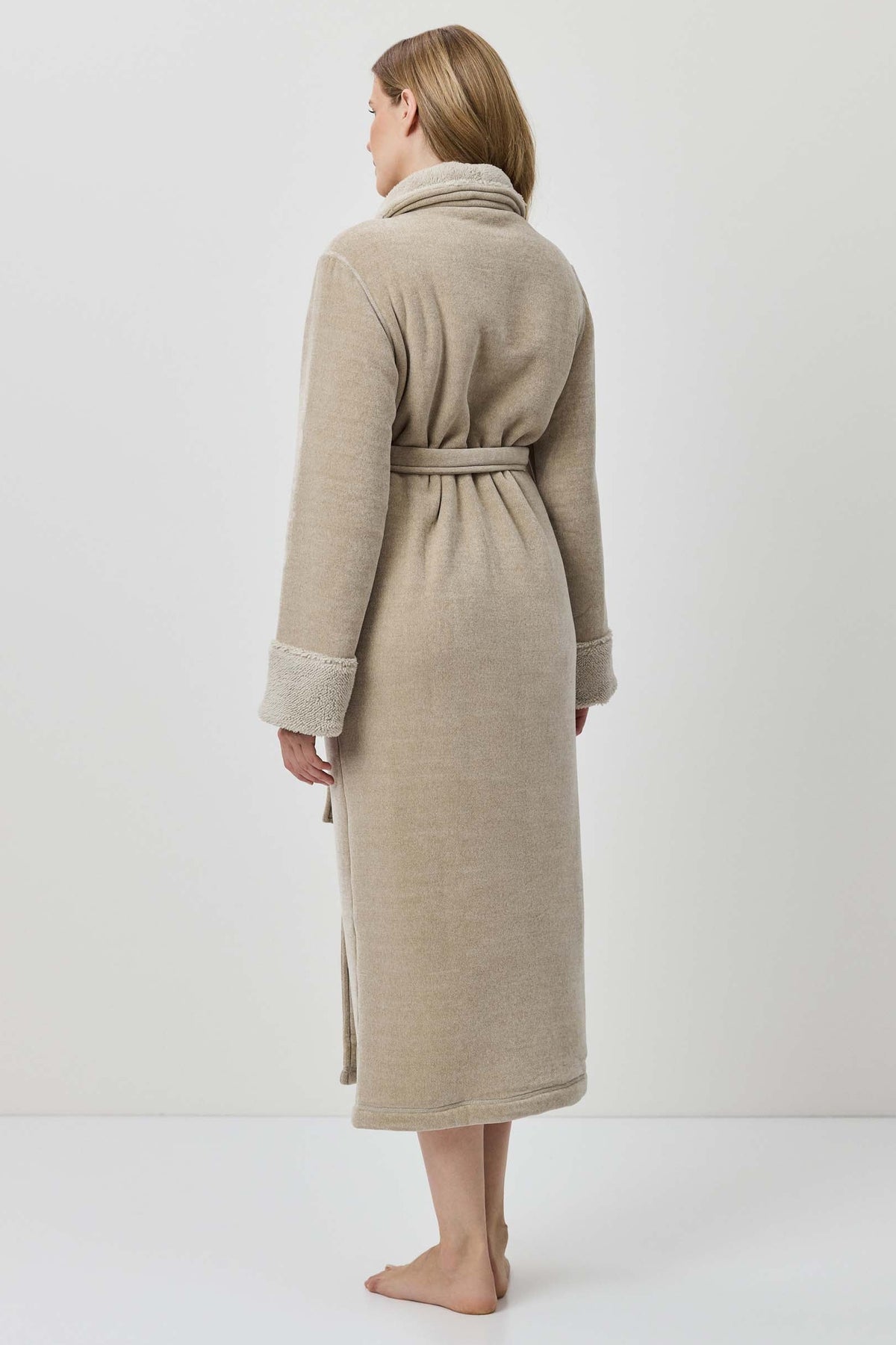 Woman wearing a beige robe against a white background