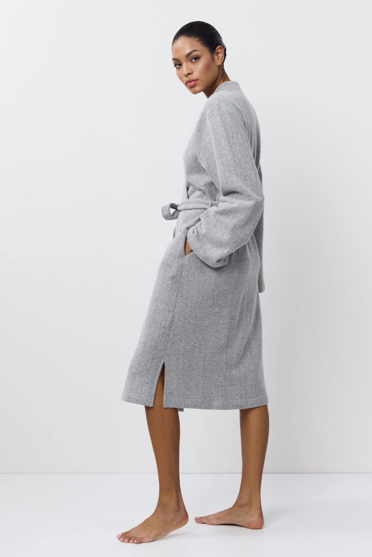 Person wearing a gray
bathrobe on a white background