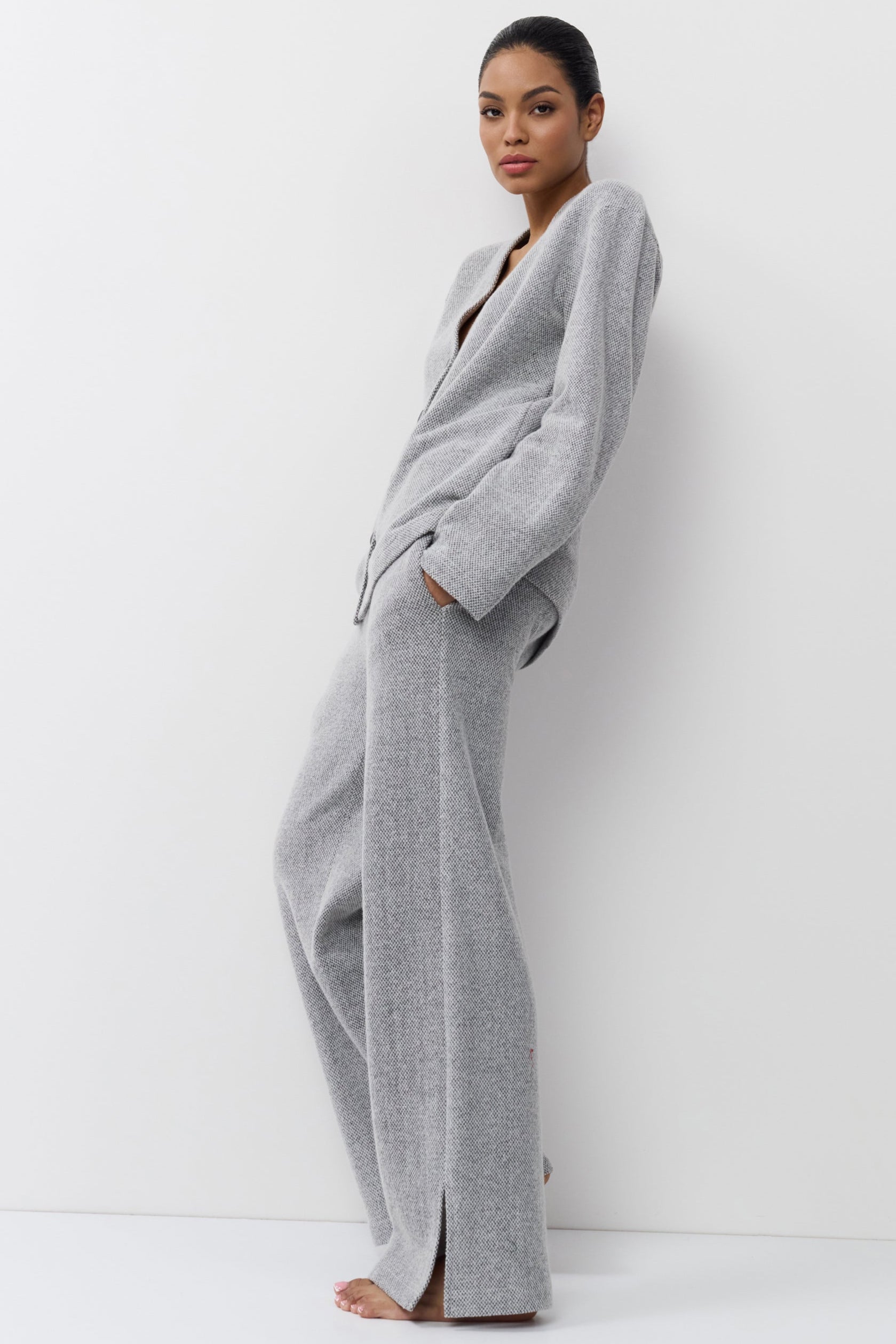 Woman wearing a gray set against a white background